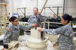 Pvt. Kaitlin Killsnight, left, Pfc. Emma Briggs, center, and Pvt. Erika Leroy work on an Abrams tank simulator during training in the 91A Abrams tank maintainers' course.