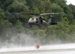 A UH-60 Blackhawk helicopter from Company B, 2nd Battalion, 147th Aviation Regiment, based out of Frankfort, Ky., fills up during water bucket firefighting training at Muscatatuck Urban Training Center in Butlerville, Ind., during Vibrant Response, Aug. 6, 2013.