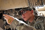 U.S. Army Spc. Michelle Metzger, a motor transport operator with the 1487th Transportation Company, Ohio Army National Guard, applies grease to her vehicle at Multinational Base Tarin Kot, Uruzgan province, Afghanistan, Aug. 12, 2013.