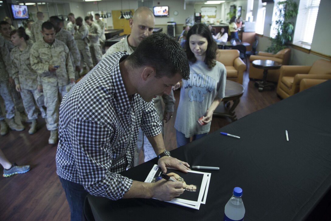 Former captain and professional Mixed Martial Arts fighter Brian Stann signs an
autograph for a Marine and his daughter at the Central Area Recreation Center
aboard Marine Corps Base Camp Lejeune, Aug. 21. Stann said he has a lot of
good memories from being stationed at Camp Lejeune, and he tries to come
back at least once a year.
