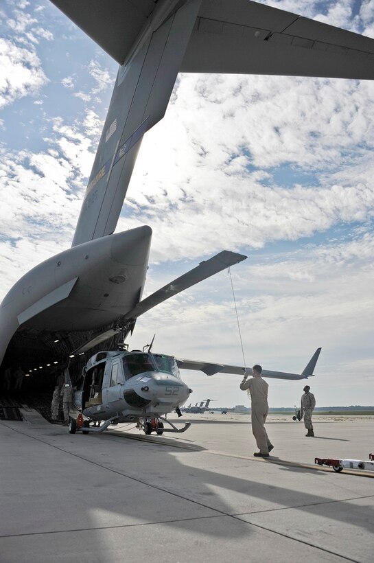 Marine Light Attack Helicopter Squadron 773 Marines and 305th Aerial Port Squadron members load a UH-1N Huey onto a C-17 Globemaster III Aug. 19, 2013, at Joint Base McGuire-Dix-Lakehurst, N.J. HMLA-773 is deploying on a Dutch ship alont the west coast of Africa. 