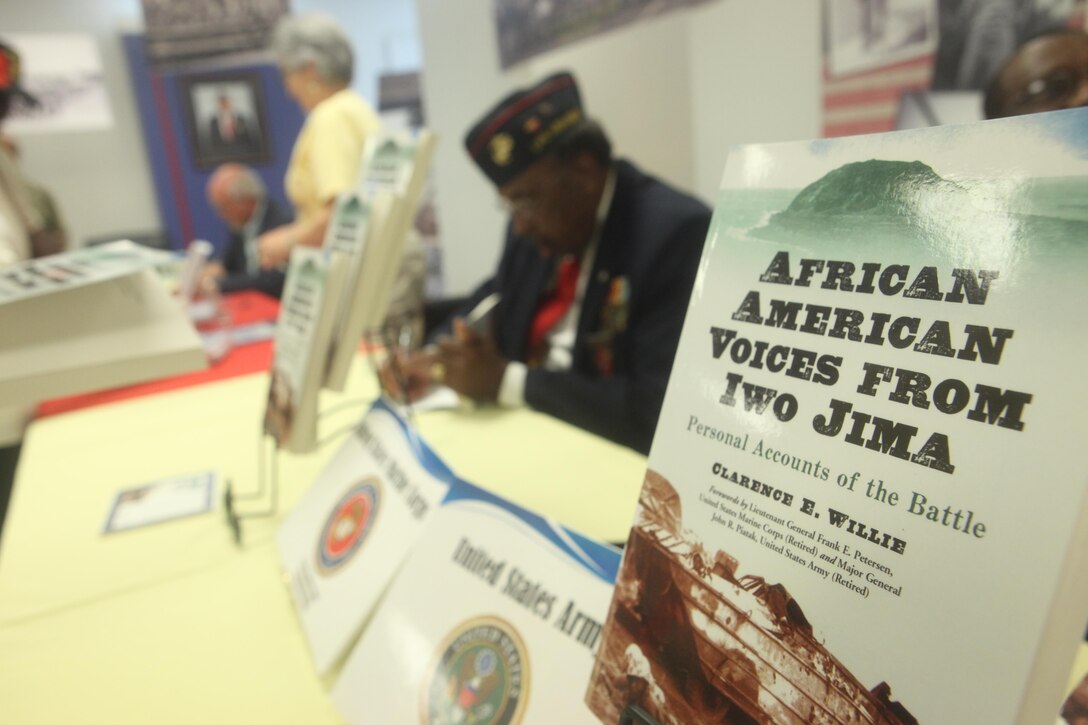 Ander Batts Jr., an original Montford Point Marine, signs a book for a patron at the Montford Point Marines Book Signing at the museum aboard Camp Johnson, Aug. 23. The book signing marked the start of three events in support of Montford Point Marines Day. 