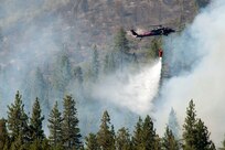 Aircrews from the California Air National Guard’s 129th Rescue Wing drop water from an HH-60 Pave Hawk helicopter on the Rim fire in the Stanislaus National Forest near Yosemite National Park, Calif., Aug. 21, 2013. Members of the California National Guard have been working with state and local officials to battle several ongoing wildfires in Northern California.