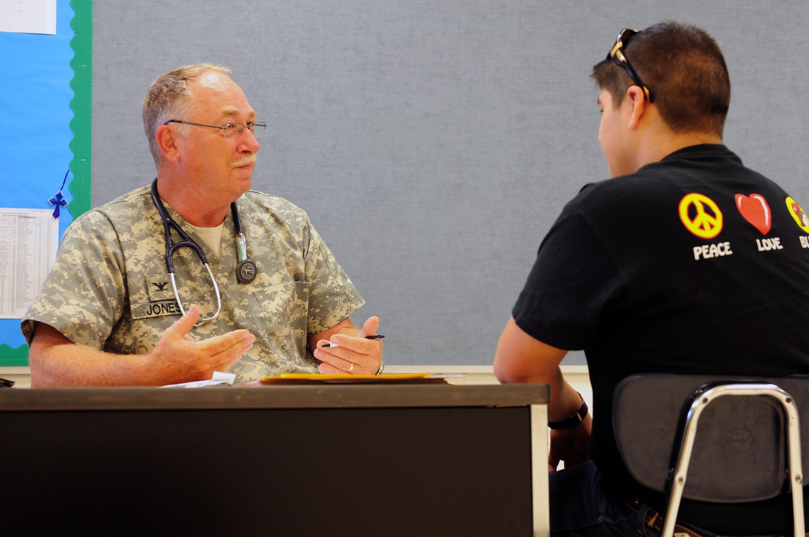 Army Col. Arnold "Skip" Jones, with Medical Command, 71st Troop Command, Texas Army National Guard, passes on medical advice to a patient during Operation Lone Star in Laredo, Texas. Operation Lone Star is a weeklong, real-time large scale emergency preparedness exercise that provides medical services and disaster recovery training to state agencies and personnel while addressing the medical needs of thousands of under-served Texas residents in the South Texas border region. 