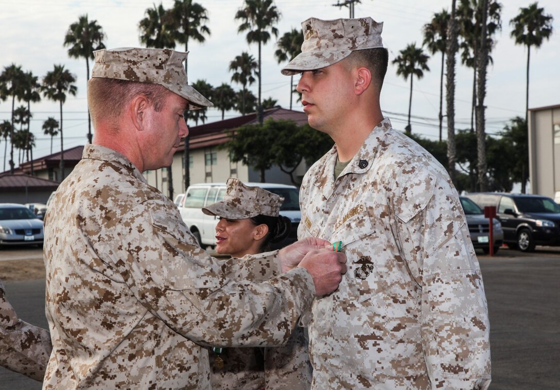 Staff Sgt. Darrol Wynn, embarkation chief, Command Element, 15th Marine Expeditionary Unit, receives a Navy and Marine Corps Achievement Medal from Lt. Col. John R. O'Neal, commanding officer, 15th MEU, during an awards ceremony held on the Camp Del Mar Parade Deck aboard Camp Pendleton, Calif., Aug. 29. Wynn received the award for the superior performance of his duties as the unit's embarkation chief. Wynn, 28, is from Detroit. (U.S. Marine Corps Photo by Cpl. Emmanuel Ramos)
