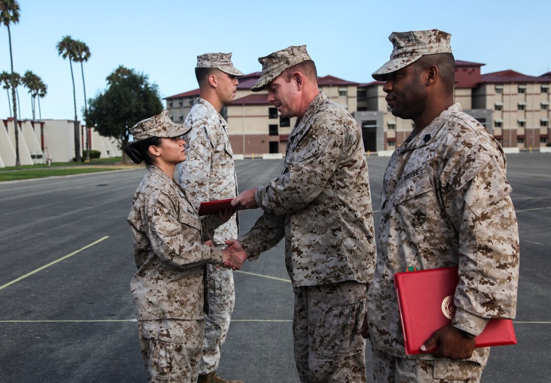 Sergeant Chenee Bibian, administrative specialist, Command Element, 15th Marine Expeditionary Unit, shakes hands with Lt. Col. John R. O'Neal, commanding officer, 15th MEU, after receiving a Navy and Marine Corps Commendation Medal during an awards ceremony held on the Camp Del Mar Parade Deck aboard Camp Pendleton, Calif., Aug. 29. Bibian received the award for the superior performance of her duties as an administrative clerk with the unit. Bibian, 23, is from Espanola N.M. (U.S. Marine Corps Photo by Cpl. Emmanuel Ramos)