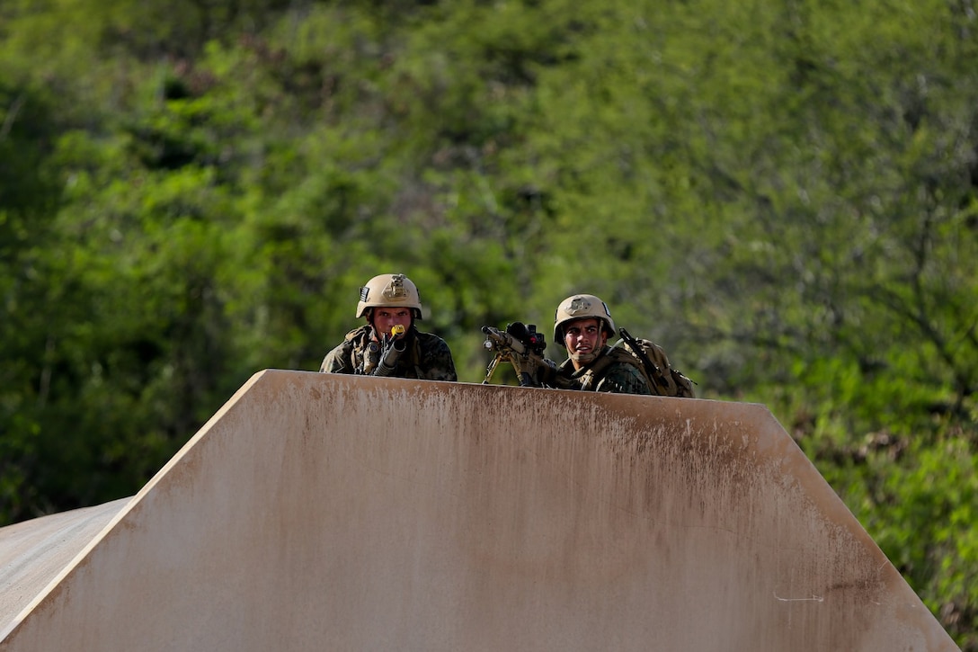 Marines serving with Alpha Company, 1st Reconnaissance Battalion, post security on a rooftop during a mission rehearsal exercise here, Aug. 20, 2013. During the exercise, Marines performed a night raid on a military operation in urban terrain town and detained possible enemy combatants. The MRX assessed the Marines' ability to execute their mission and coordinate logistics with their command element as they prepare to deploy with the 11th Marine Expeditionary Unit next year.