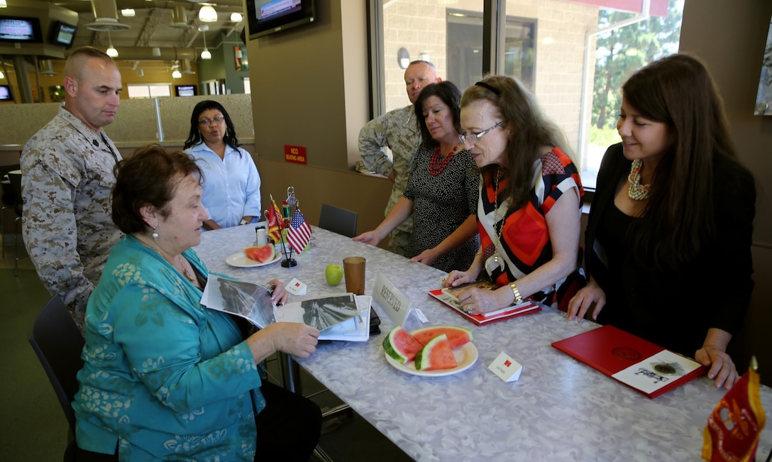 MARINE CORPS BASE CAMP PENDLETON, Calif. – Faye Jonason (left), the museum officer of 1st Marine Division, shows Gen. Alexander A. Vandegrift’s granddaughter and great granddaughter, Vallerey and Serina Vandegrift, photographs of the history of Camp Pendelton during a visit here, Aug. 27, 2013. General Vandegrift was a Medal of Honor recipient and commanded the division during 1942 in its first ground offensive of World War II, the Battle of Guadalcanal.