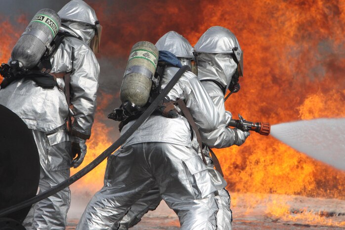 Aircraft Rescue Fire Fighting Marines extinguish a fire during live-fire training at the burn pit aboard Marine Corps Air Station Iwakuni, Japan, Aug. 23, 2013. While conducting live-fire training, two Marines man the hose while a senior Marine observes closely to make sure they are performing the proper procedures. ARFF Marines Conduct this type of training a few times a month, generally on Fridays, to stay proficient in their training so they can effectively respond to any crisis.