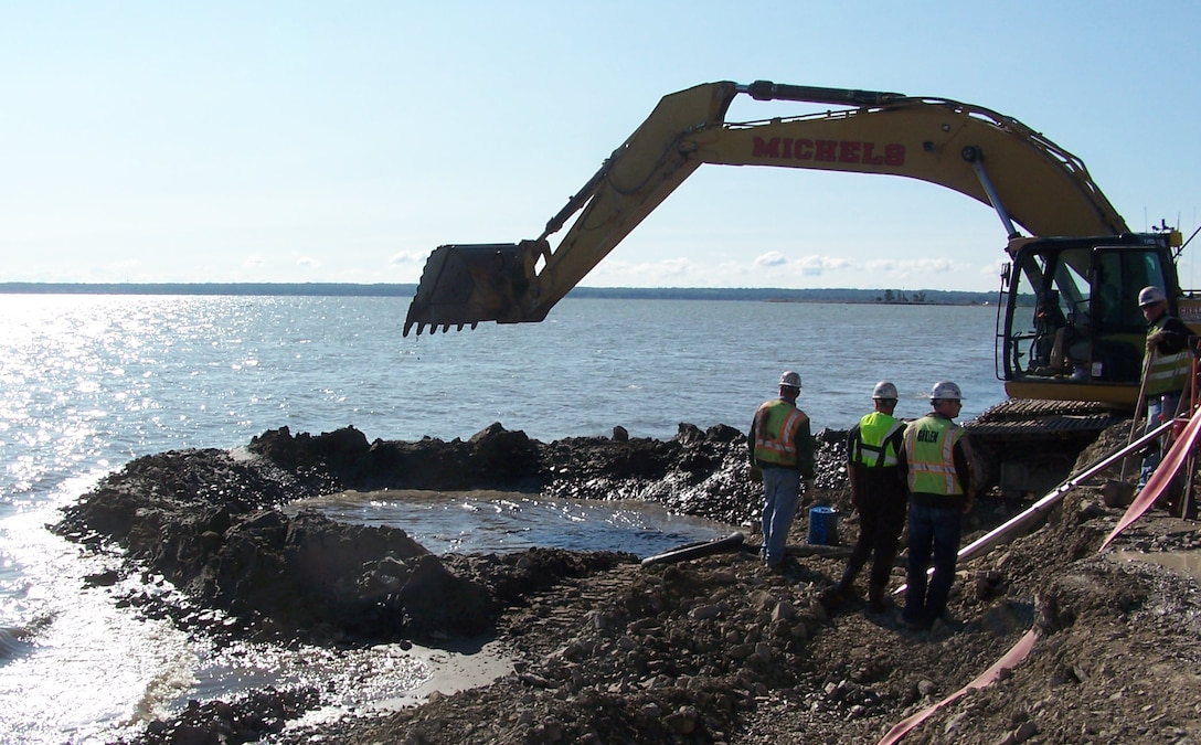Contractors working on the Cat Island Restoration Project in Green Bay, Wis. excavate a trench for the reinforced concrete pipe, RCP, (culvert) for water flow between the islands. 