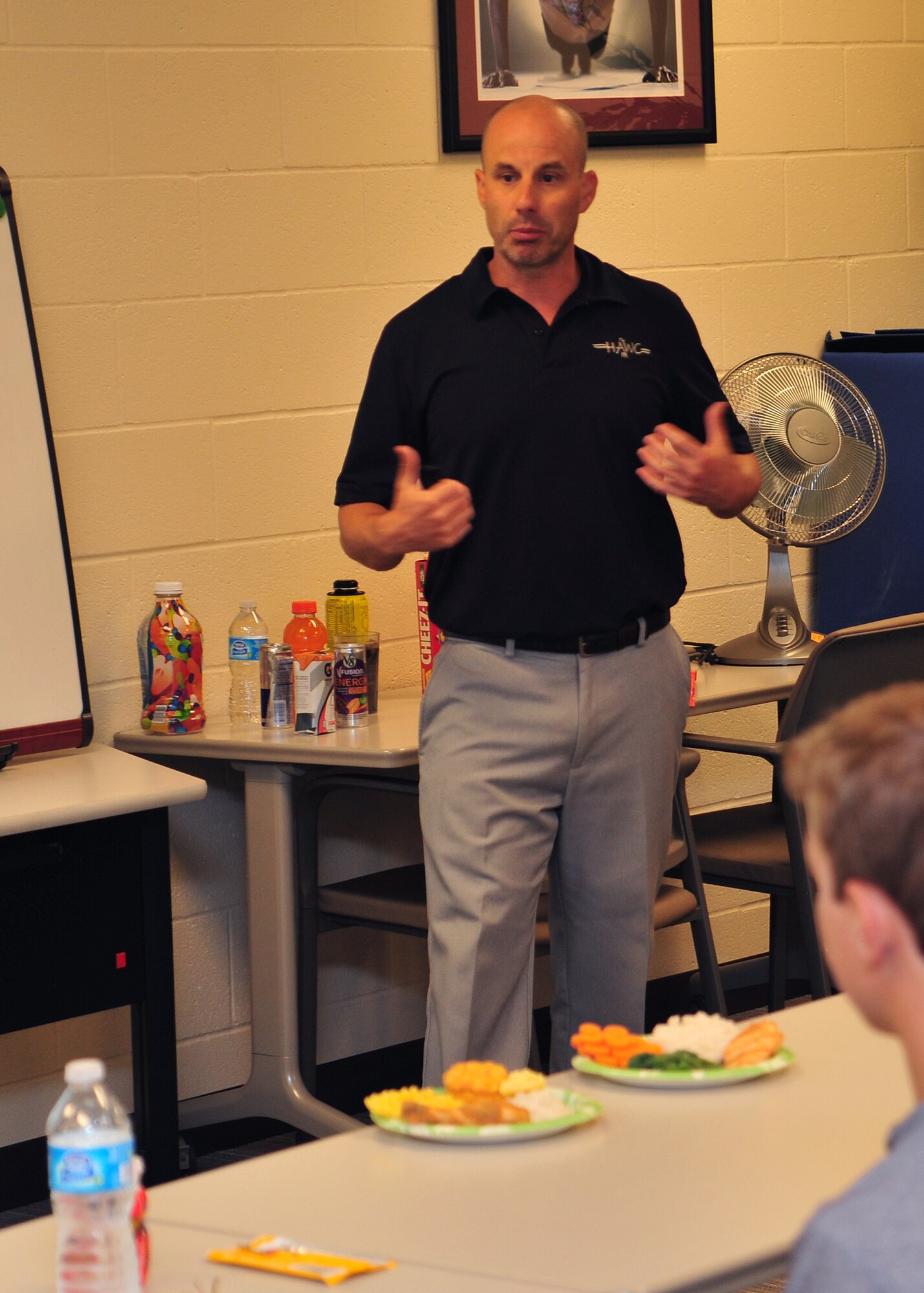 Will Saultes, 92nd Aerospace Medicine Squadron Health and Wellness Clinic health promotion manager, speaks to kids at a Youth Clinic to discuss sports nutrition education, injury prevention and tips on how to improve performance at home and school at Fairchild Air Force Base, Wash., Aug. 27, 2013. The class was broken into two sections focusing on nutrition and sports performance.  (U.S. Air Force photo by Staff Sgt. Michael Means/Released)
