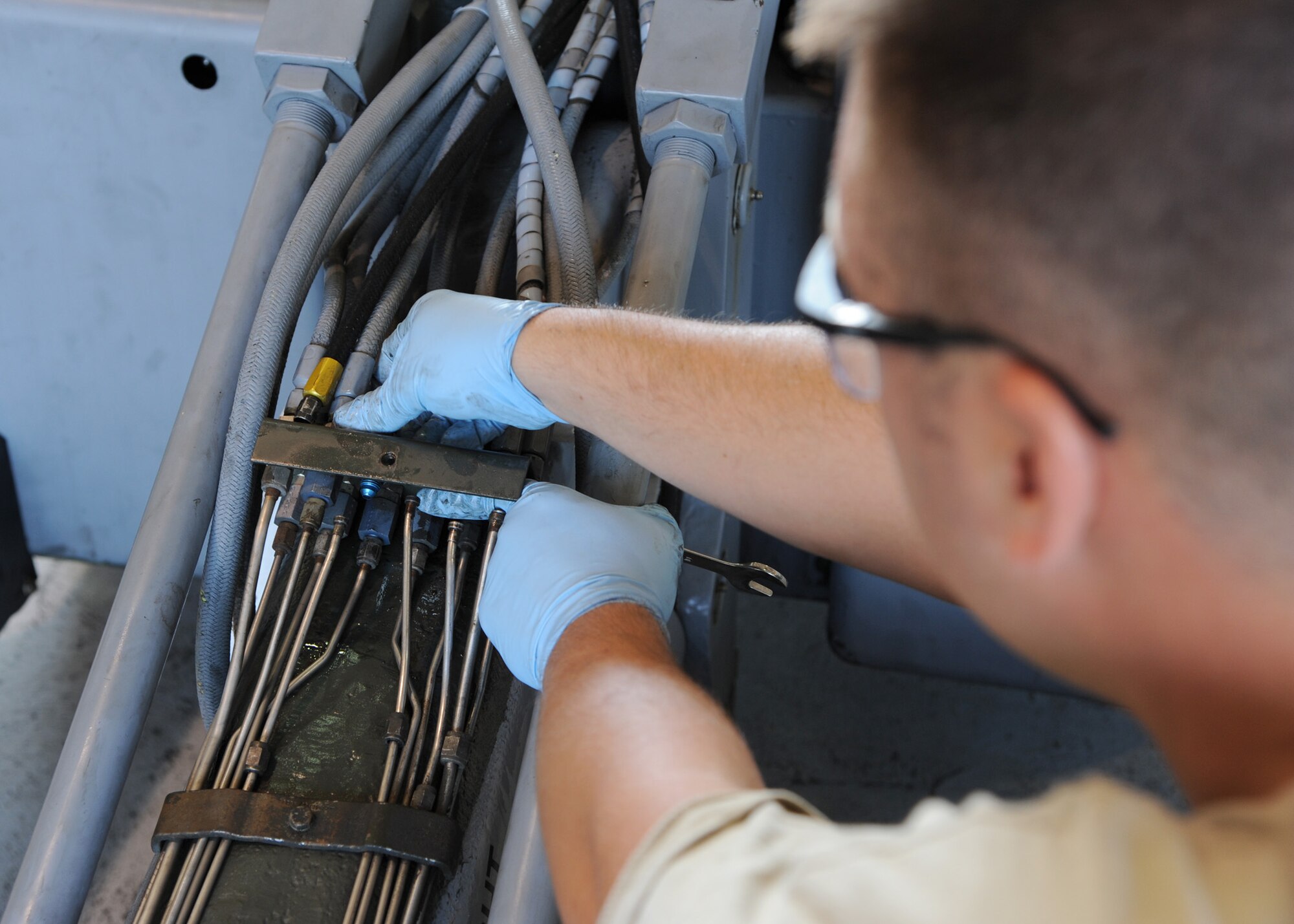 Senior Airman Nicholas Lindner, 307th Aerospace Ground Equipment journeyman, replaces unions on a MHU-83 bomb loader at Barksdale Air Force Base, La., Aug. 28, 2013. Lindner used slim-line wrenches and a crescent wrench to remove the stripped unions that connect hydraulic lines. (U.S. Air Force photo/Senior Airman Joseph A. Pagán Jr.)