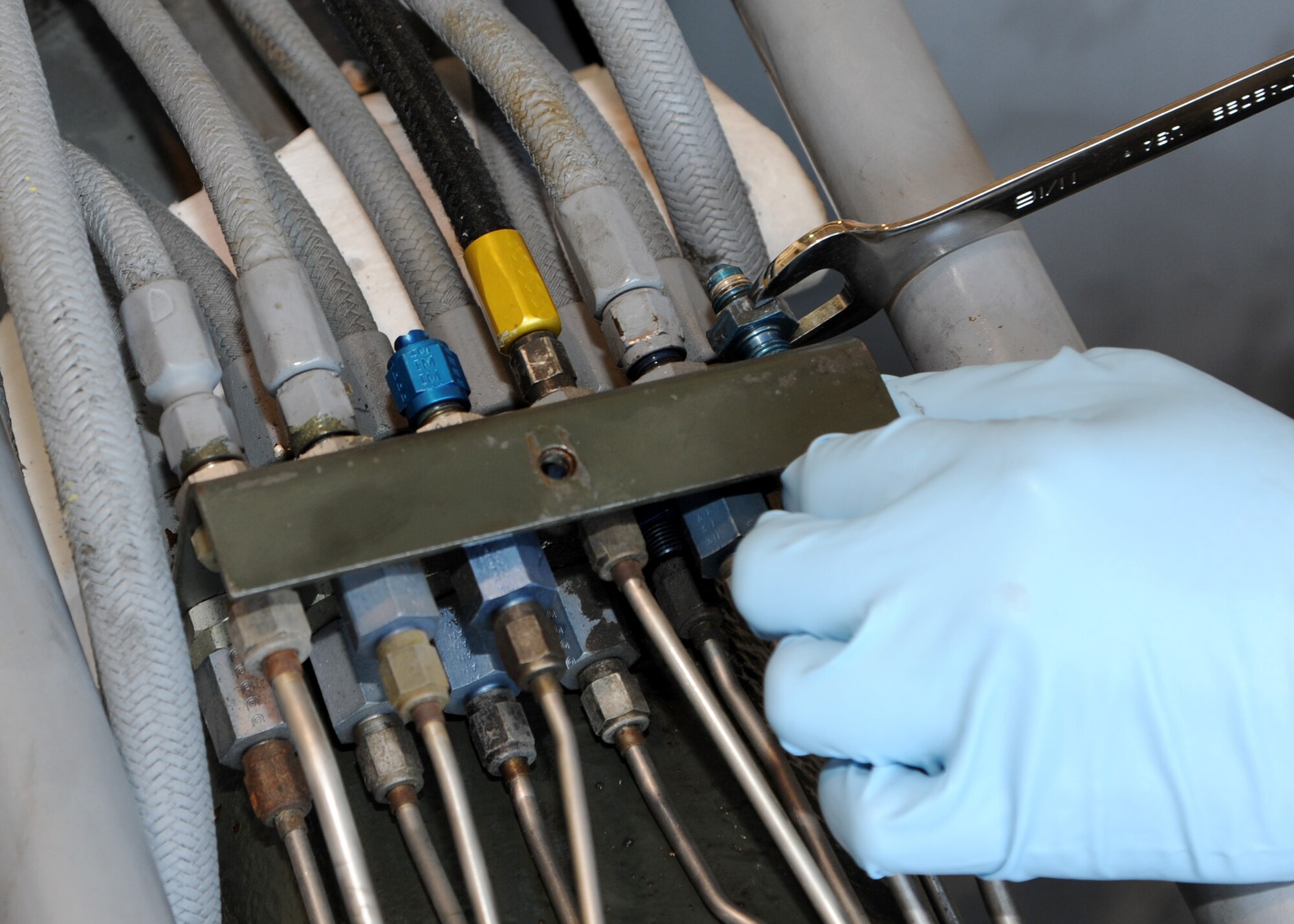 Senior Airman Nicholas Lindner, 307th Aerospace Ground Equipment journeyman, uses slim-line wrenches and crescent wrench to remove unions from a MHU-83 bomb loader on Barksdale Air Force Base, La., Aug. 28, 2013. The unions connect hydraulic lines and have holes down the middle, so hydraulic fluid can flow from one line to the next.  (U.S. Air Force photo/Senior Airman Joseph A. Pagán Jr.)