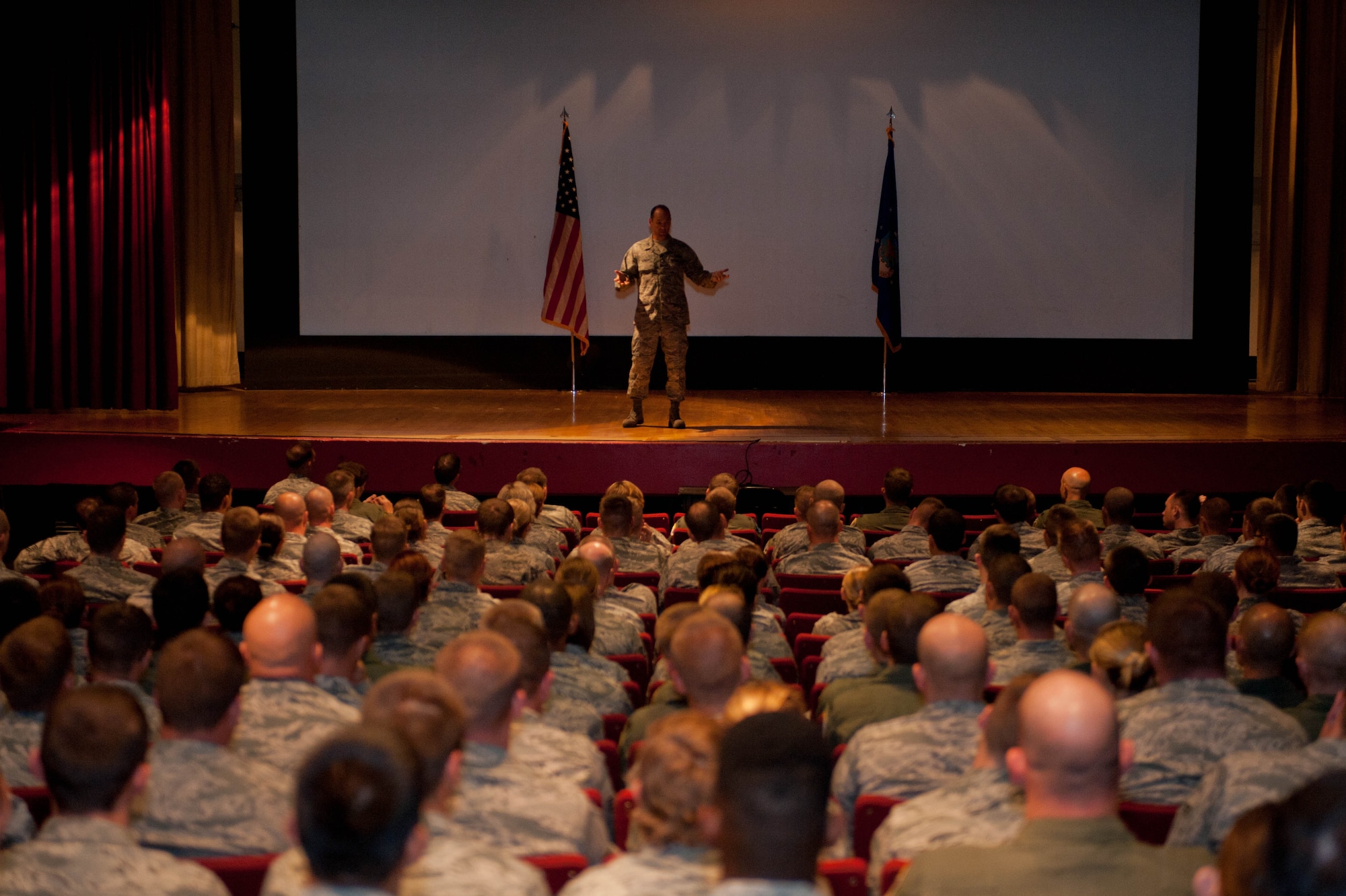 Ellsworth Airmen listen as Col. Kevin Kennedy, 28th Bomb Wing commander, explains his priorities during a commander's call in the base theater at Ellsworth Air Force Base, S.D., Aug. 29, 2013. Among the areas covered, safety was the main focus, with an emphasis on the importance of practicing operational risk management in the decision making process. (U.S. Air Force photo by Airman 1st Class Zachary Hada/Released)