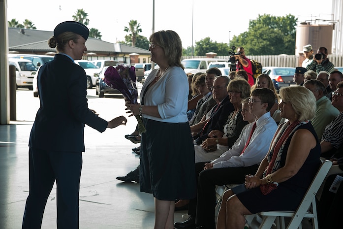 Michelle DeVore, wife of Col. Jeffrey DeVore, receives a bouquet of flowers welcoming her to Charleston during the JB Charleston Change of Command ceremony, Aug. 29, 2013, at JB Charleston – Air Base. DeVore, previously the commander of the 386th Expeditionary Operations Group, Southwest Asia, officially assumed command from Col. Richard McComb  during the change of command ceremony. McComb will be assuming duties at the Pentagon, Washington D.C. As the JB Charleston commander, McComb provided installation support to a total force of more than 86,000 Airmen, Sailors, Soldiers, Marines, Coast Guardsmen, civilians, dependents and retirees across both the Air Base and Weapons Station. (U.S. Air Force photo/Tech. Sgt. Rasheen Douglas