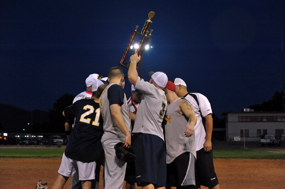 Members of the 898th Munitions Squadron intramural softball team hoist the trophy after winning the championship game 16-12 over the 377th Weapons System Security Squadron. (Photo by Ken Moore)