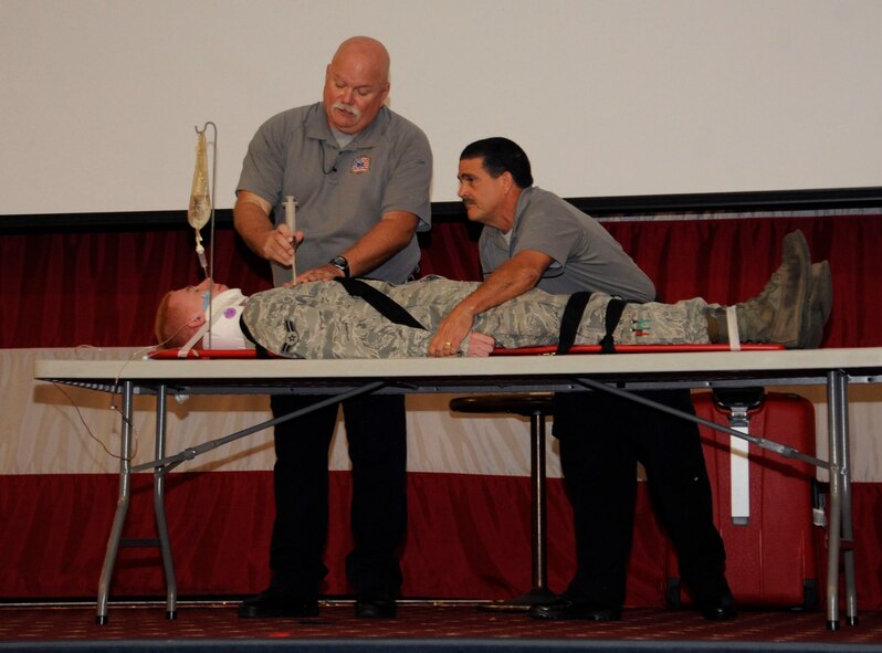 Greg McCarty and Ronny Garcia, Street Smart presenters, demonstrate the insertion of a chest tube on Airman 1st Class Williams Franks, 2nd Maintenance Squadron crew chief, during a safety briefing before the Labor Day weekend on Barksdale Air Force Base, La., Aug. 29, 2013. The chest tube is one of the many tools paramedics and doctors use to alleviate a collapsed lung, an injury commonly found in vehicle mishaps when individuals do not wear seatbelts. (U.S. Air Force photo/Airman 1st Class Andrew Moua)