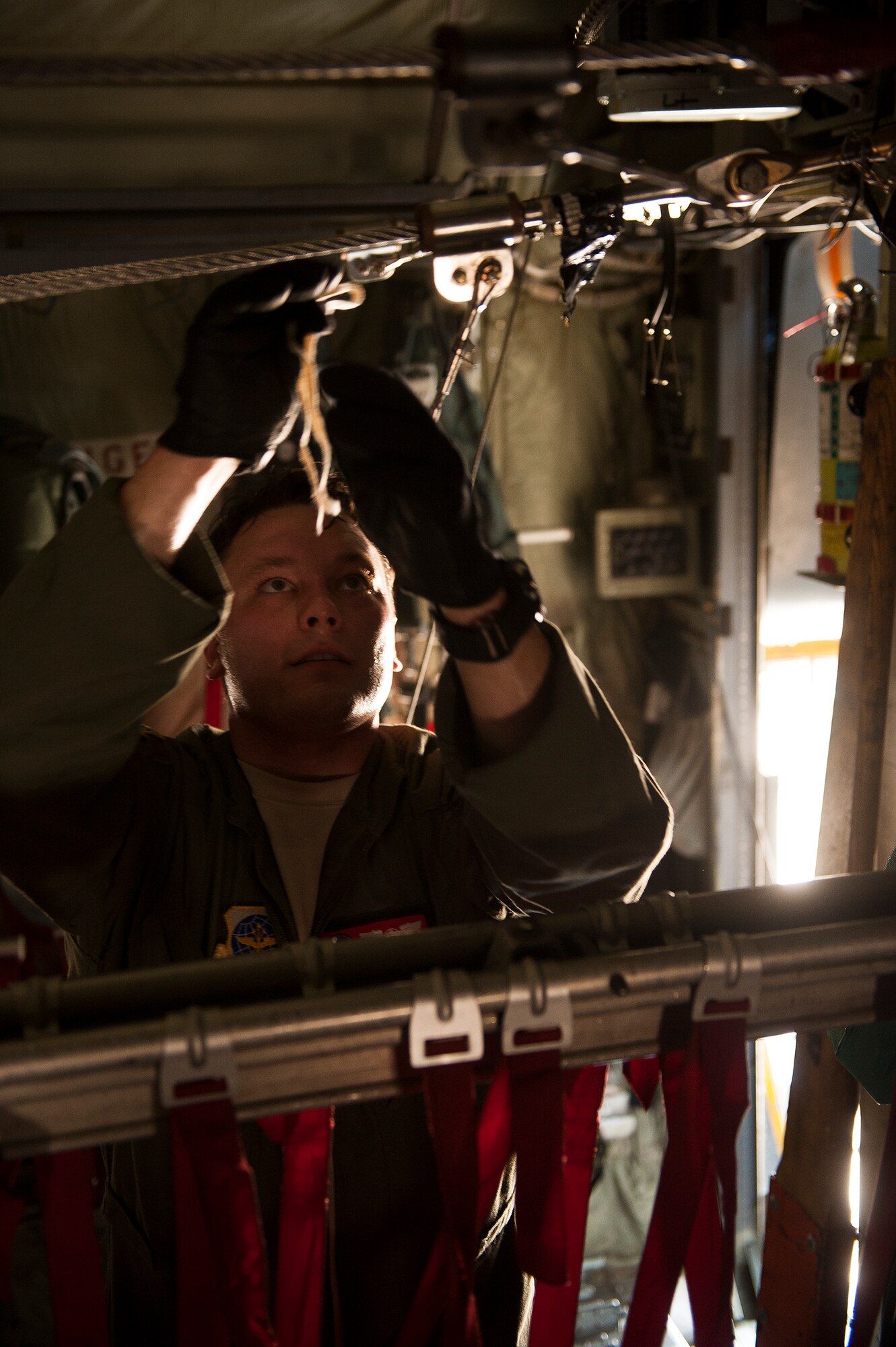 U.S. Air Force Staff Sgt. Jeremiah Lindstrom, a 50th Airlift Squadron loadmaster, secures a cable in preparation for a personnel drop Aug. 18, 2013, at Little Rock Air Force Base, Ark. Lindstrom was part of a C-130H crew participating in Joint Operational Access Exercise 13-0X, part of a multi-day combined military training exercise designed to prepare Airmen and soldiers to respond to worldwide crises and contingencies. (U.S. Air Force photo by Staff Sgt. Russ Scalf)