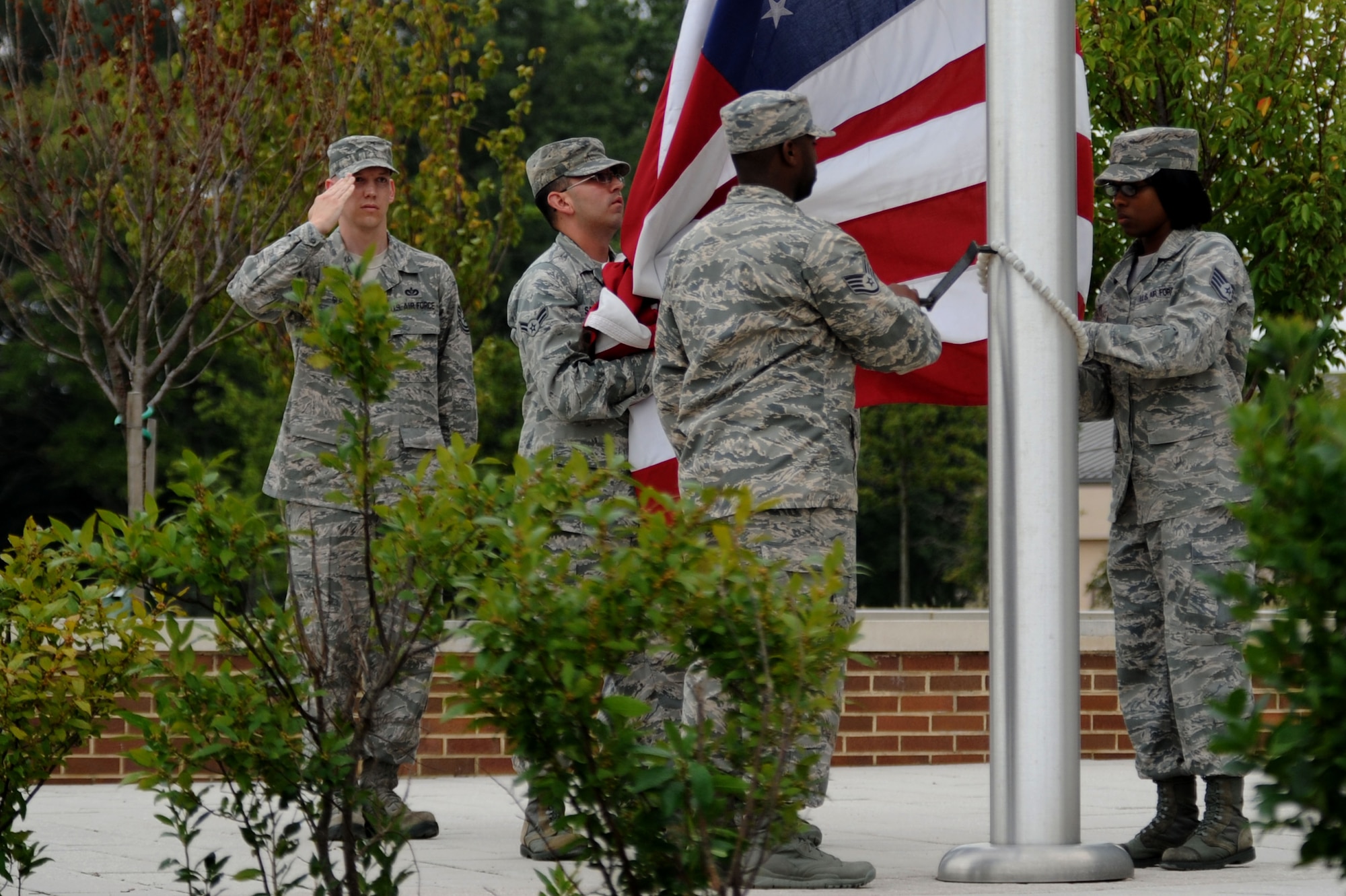 Tech. Sgt. Brad Gurley, NCOIC of the flag detail, salutes as Airmen lower the flag during the final Air Force District of Washington retreat ceremony of the year at Joint Base Andrews, Md., Aug. 29, 2013. Gurley is the AFDW command chief’s executive assistant. (U.S. Air Force photo by Tech. Sgt. Tammie Moore)