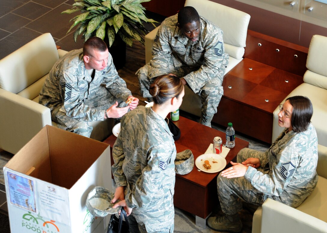 A group of Air Force District of Washington Airmen enjoy their lunchs during AFDW Food For Food Donation Lunch Festival Aug. 28, 2013, at Joint Base Andrews, Md. Indivduals were able to donate nonparishable food or make a monitary donation for their lunches to benefit Feds Feed Families during the festival. The lunch festival donation drive netted 4,801 pounds of non-perishable food for the campaign. (U.S. Air Force photo by Tech. Sgt. Tammie Moore)
