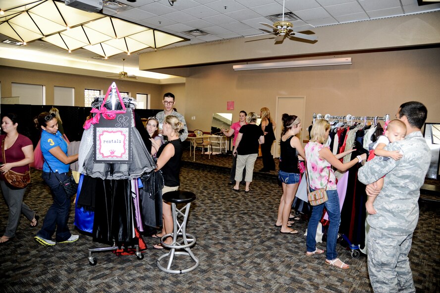 Members of the Luke community look through dresses at the opening of the Cinderella and Prince Charming Closet at the Airmen’s Attic. The closet provides one free formal outfit for spouses of staff sergeants and below so they can attend formal events like graduations or the Air Force Ball. The closet also has both suits and gowns that can be rented. (U.S. Air Force photo/Staff Sgt. C.J. Hatch)