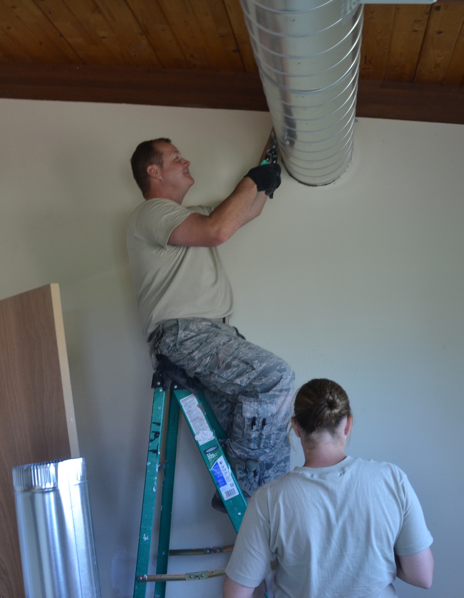 Missouri Air National Guard Master Sgt. Cliff Swyers and Staff Sgt. Sarah Bequette, both 131st Civil Engineer Squadron heating ventilation air condition technicians, install ventilation in a “hogan,” or Navajo building, at St. Michaels Academy in Window Rock, Ariz., Aug. 8, 2013. The 131st CES crew members provided construction and home renovations to help assist the physically and mentally handicapped children and adults of the Navajo nation. (U.S. Air Force photo/Released)