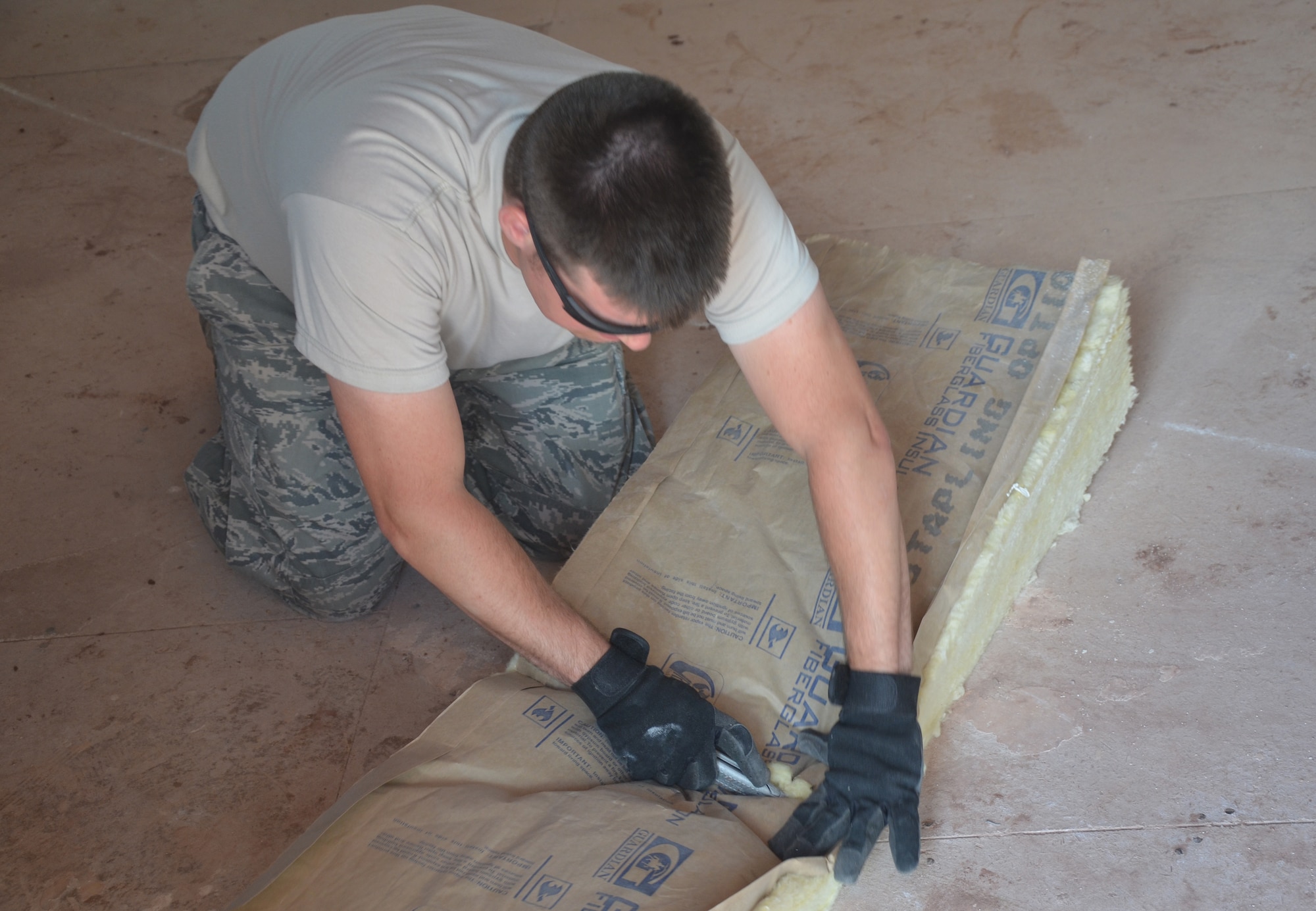 U.S. Air Force Staff Sgt. Brian O’Shea, 131st Civil Engineer Squadron structural technician, cuts insulation for a “hogan,” or Navajo building, at St. Michaels Academy in Window Rock, Ariz., Aug. 8, 2013. This project helped ensure handicap children were able to live in a comfortable home with modern amenities. (U.S. Air Force photo/Released)