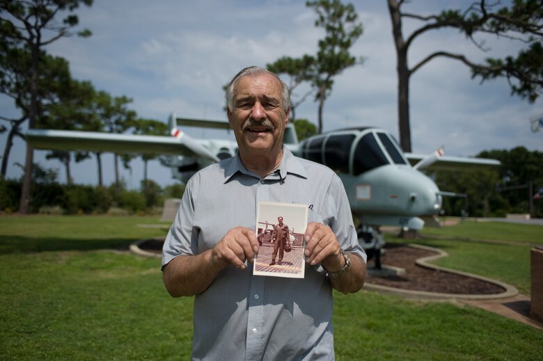 Kenneth Krohn, a local business owner and former Air Force pilot, poses in front of the exact aircraft he flew during the Vietnam War while holding a picture of himself posing in front of the same aircraft at the air park on Hurlburt Field, Fla., Aug. 12, 2013.  Krohn primarily flew the OV-10 Bronco during the Vietnam War, mainly performing reconnaissance missions. (U.S. Air Force photo/ Senior Airman Hayden Hyatt)