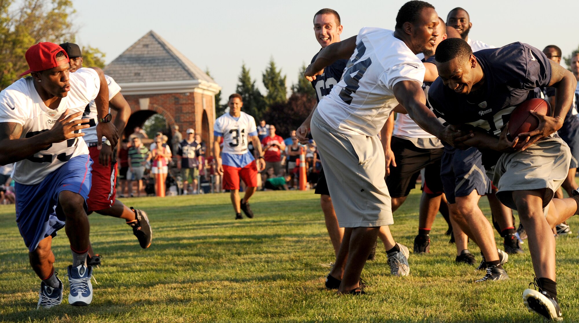An Airman runs past a St. Louis Rams player during a scrimmage Aug. 28, 2013, Scott Air Force Base, Ill. The scrimmage provided an opportunity for the Rams to meet with servicemembers and participate in friendly competition. (U.S. Air Force photo/ Senior Airman Tristin English)
