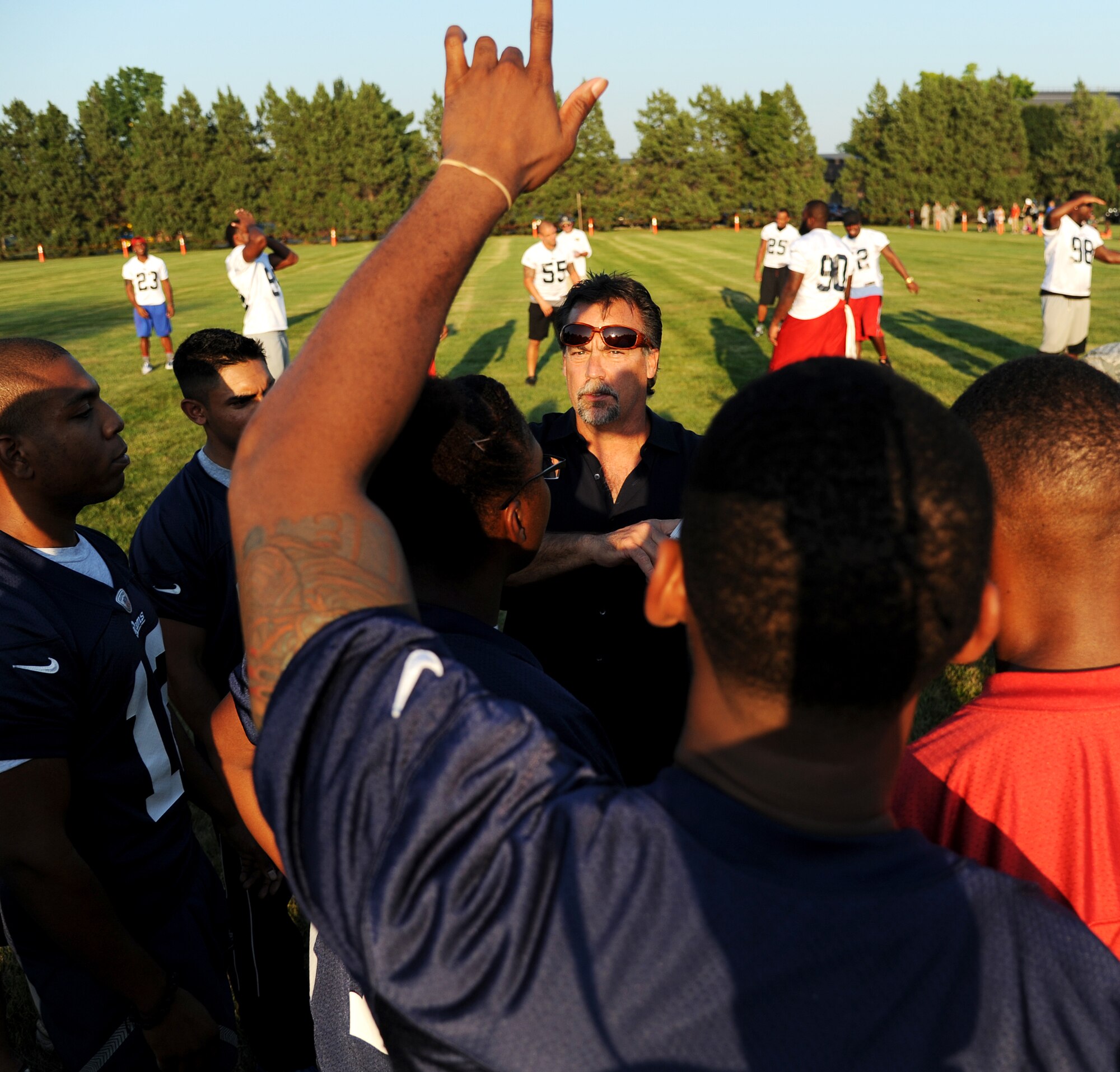 Jeff Fisher, St. Louis Rams head coach, goes over a play with Team Scott members during a scrimmage against the St. Louis Rams Aug. 28, 2013, Scott Air Force Base, Ill. The scrimmage provided an opportunity for the Rams to give back to a large part of the local community and show respect for what service members do on a daily basis. (U.S. Air Force photo/ Senior Airman Tristin English)