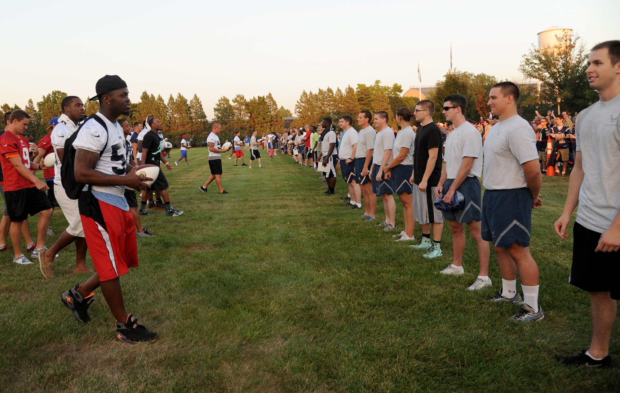 Members of the St. Louis Rams football team hand out autographed footballs to Team Scott Airmen after a scrimmage Aug. 28, 2013, Scott Air Force Base, Ill. The Rams visit was the second to Scott AFB. (U.S. Air Force photo/ Senior Airman Tristin English)