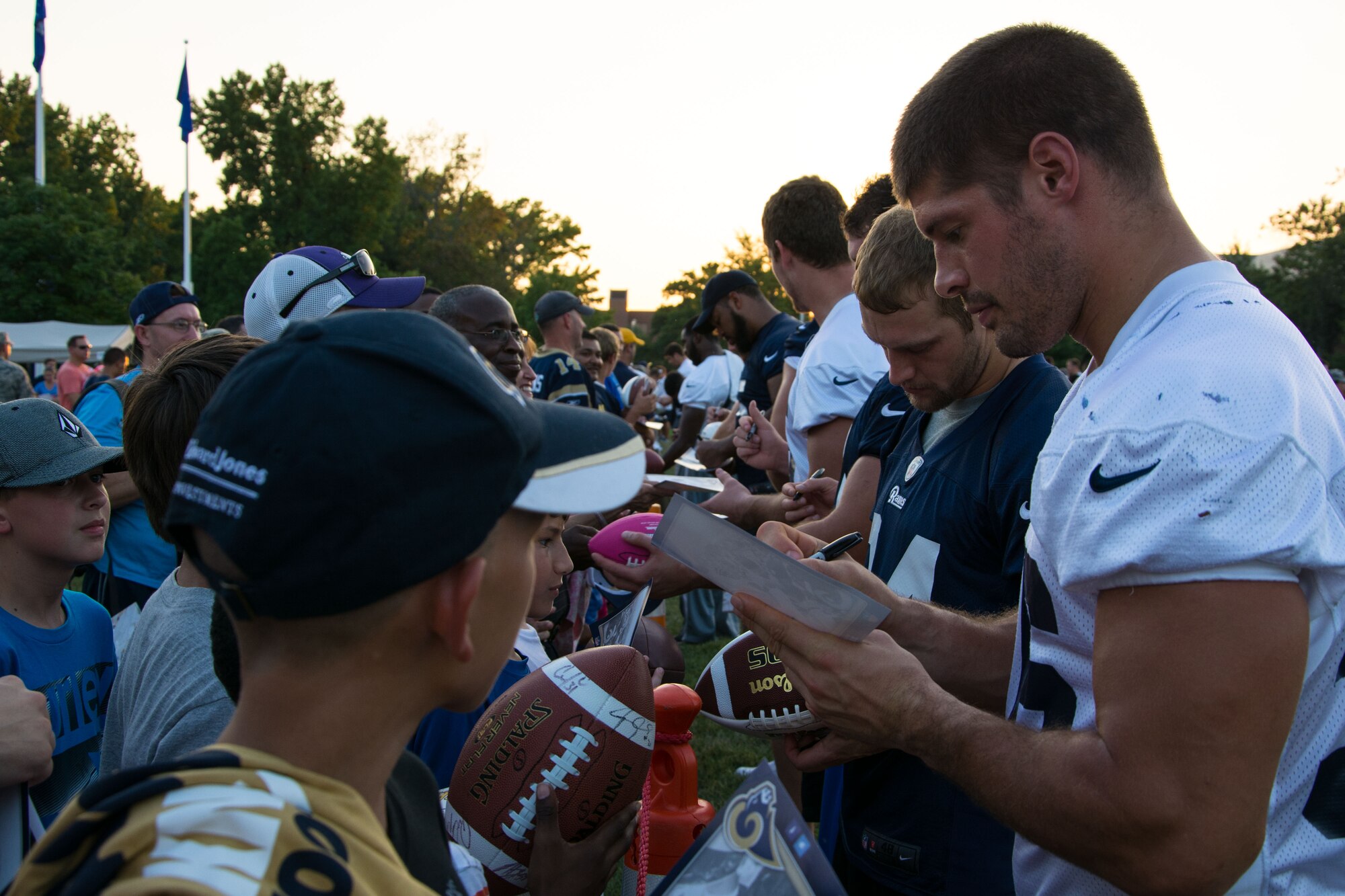 Members of the St. Louis Rams autograph footballs and photos during a visit to Scott Air Force Base, Ill., Aug. 28, 2013. This was part of the Rams annual visit to the base which also included a number of scrimages versus a team of Scott AFB Airmen and young children. (U.S. Air Force photo/Staff Sgt. Jonathan Fowler)