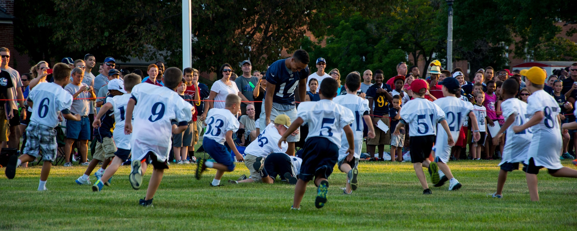 Emory Blake attempts to get the football from a team of young children Aug. 28, 2013, Scott Air Force Base, Ill. Blake and the rest of the St. Louis Rams played against a team of Scott AFB Airmen and a team of children while visiting the base. Blake is a wide reciever for the Rams. (U.S. Air Force photo/Staff Sgt. Jonathan Fowler)