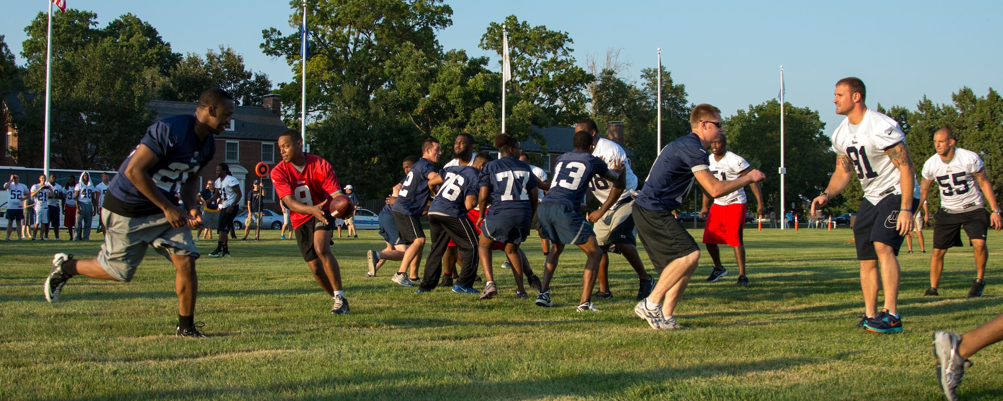 The Airmen team performs a running play against members of the St. Louis Rams during their visit Aug. 28, 2013, to Scott Air Force Base, Ill. The Airmen team had the oppurtunity to scrimage with Rams and get autographs from the team. (U.S. Air Force photo/Staff Sgt. Jonathan Fowler)