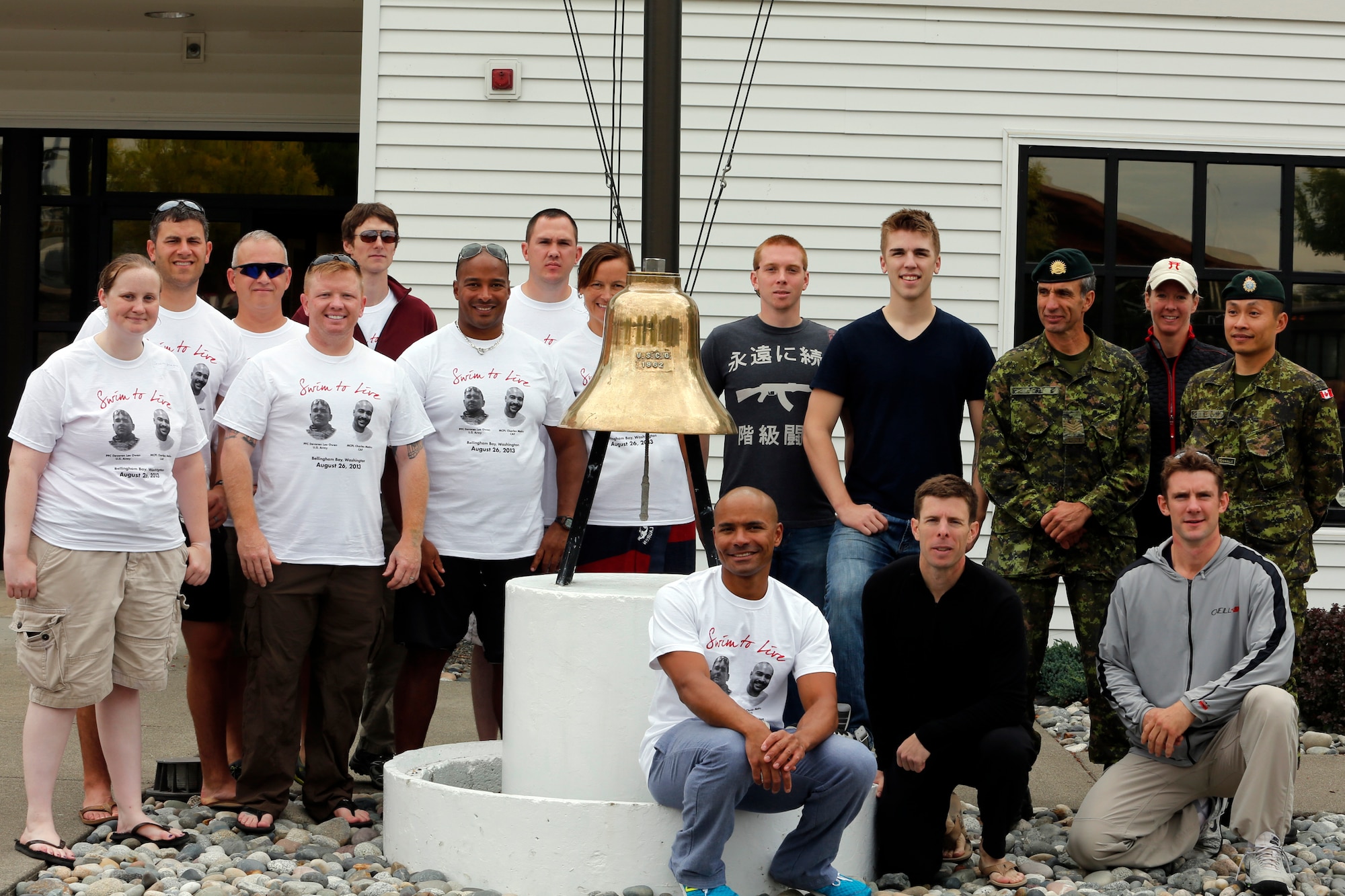 Participants of the 2013 Josh Fueston Swim to Live stand in front of the U.S. Coast Guard station, Aug. 25, 2013, in Bellingham, Wash. For the event, 16 swimmers from the United states and Canada came together to honor those whose lives have been affected by post-traumatic stress disorder and to help raise support for those who are affected. (U.S. Air Force photo/Capt. Rachel Ianacone)