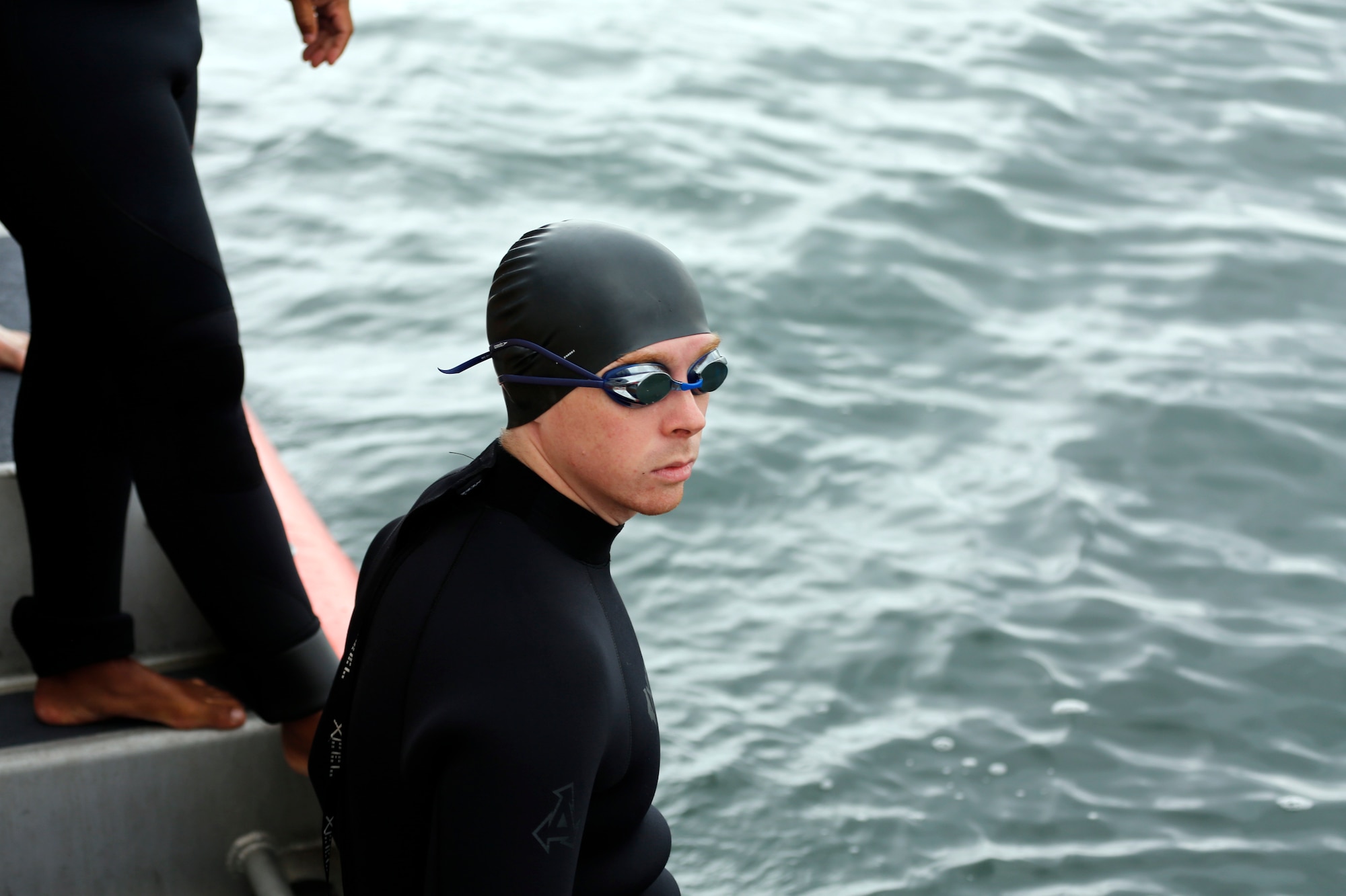 Staff Sgt. Nathan Carlson, 62nd Aerial Port Squadron safety and security manager, sits on the edge of the U.S. Coast Guard vessel waiting for his signal to jump into the water, Aug. 25, 2013, in Bellingham, Wash. Carlson was one of 16 participants in the 2013 Josh Fueston Memorial Swim to Live event. (U.S. Air Force photo/Capt. Rachel Ianacone)