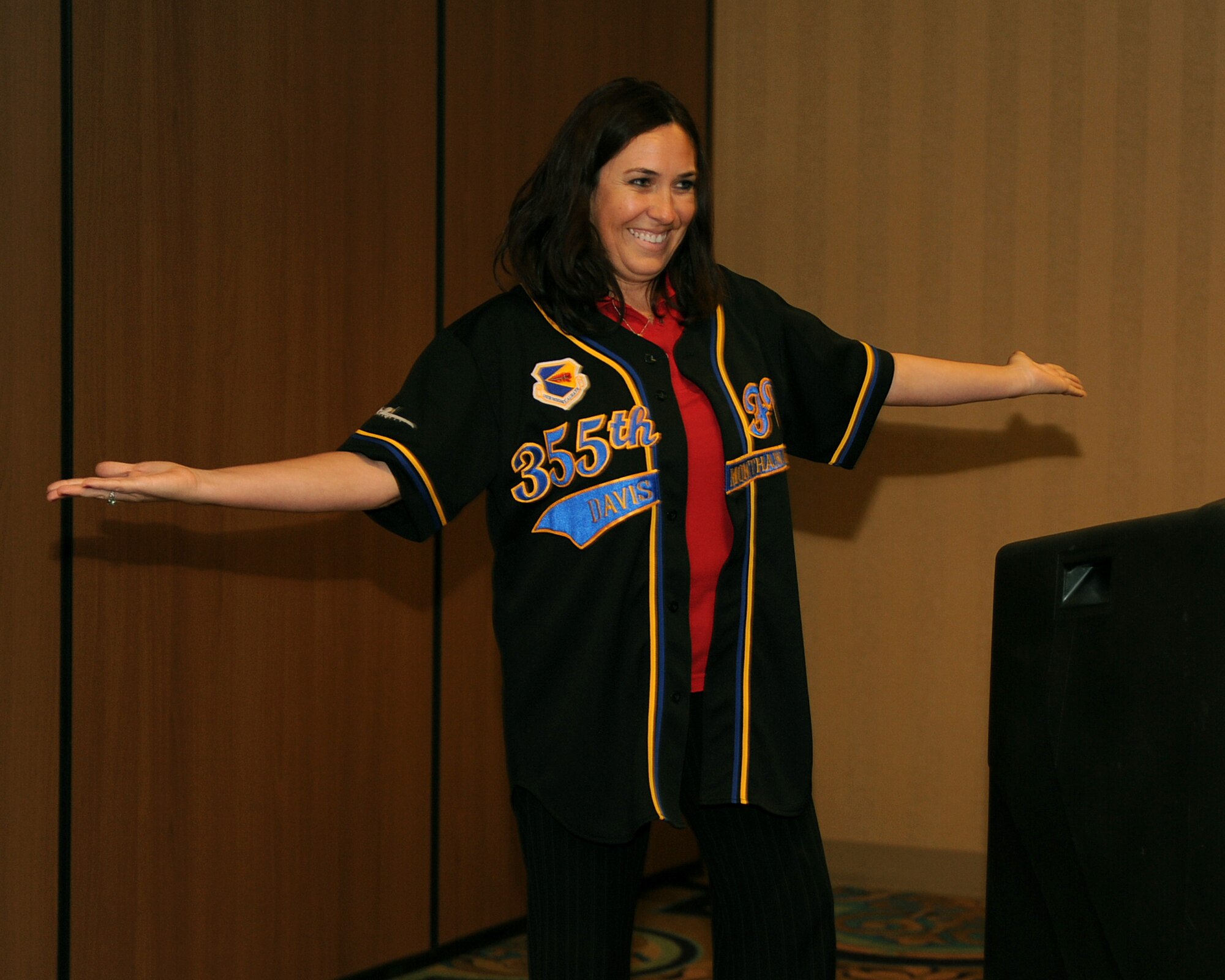 Ellen Jimenez, the chairman of the Military Affairs Committee of the Tucson Metropolitan Chamber of Commerce, displays 355th Fighter Wing jersey given to her by base leadership for her efforts in supporting the base at Davis-Monthan Air Force Base, June 14, 2012. As a member of the MAC, Jimenez has helped to foster understanding and cooperation between military and civilian communities in Tucson, Ariz. (U.S. Air Force photo by Airman 1st Class Christine Griffiths/Released)