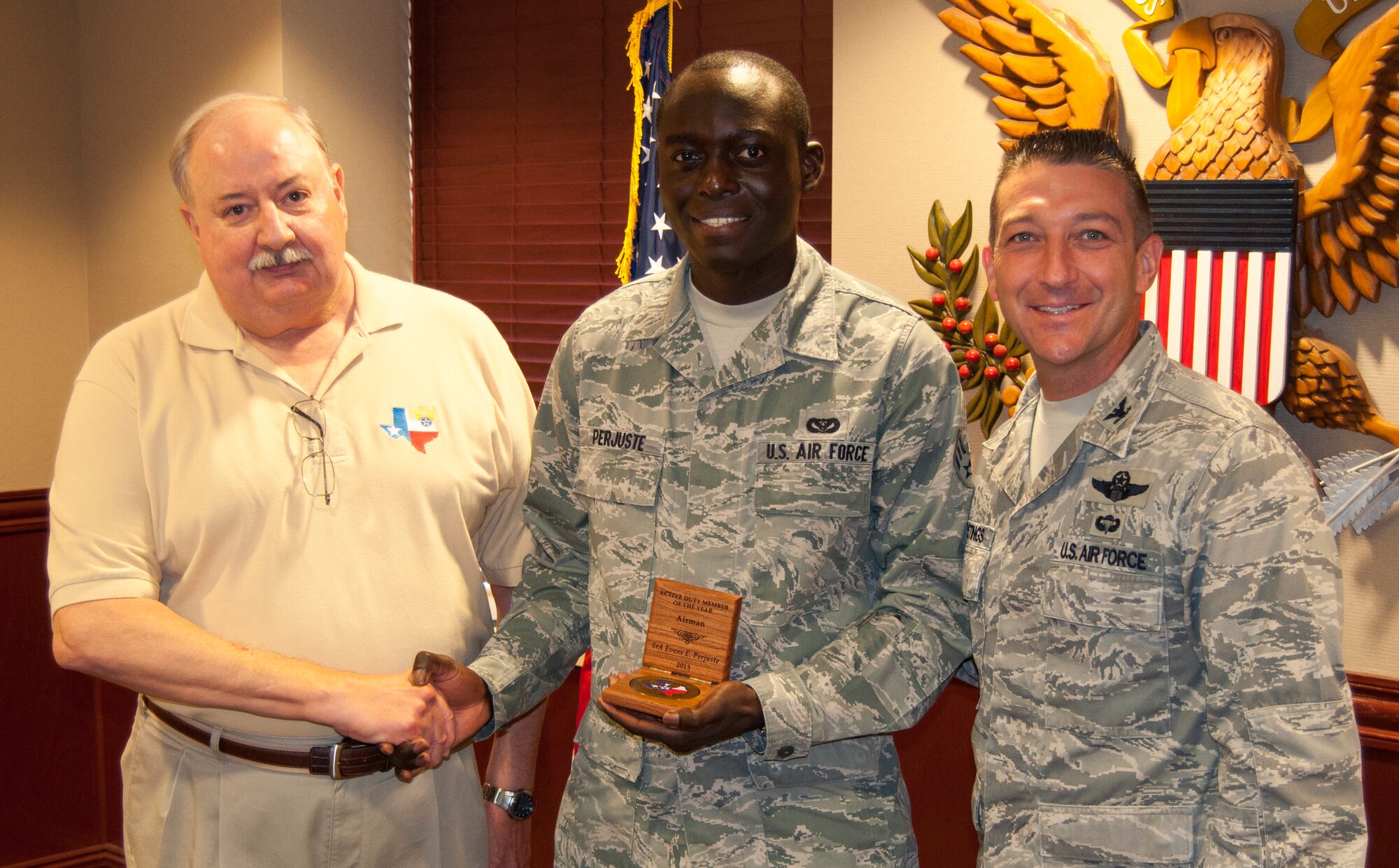 Senior Airman Evens Perjuste, 47th Civil Engineer Squadron, poses with Col. Brian Hastings, 47th Flying Training Wing commander and Larry Martwig, Air Force Association regional director, after being presented the AFA of Texas Airman of the Year award Aug. 27, 2013, at Laughlin Air Force Base, Texas. Perjuste was selected for the award due to his unparalleled dedication to service in and out of uniform.  (U.S. Air Force photo/Joel Langton)