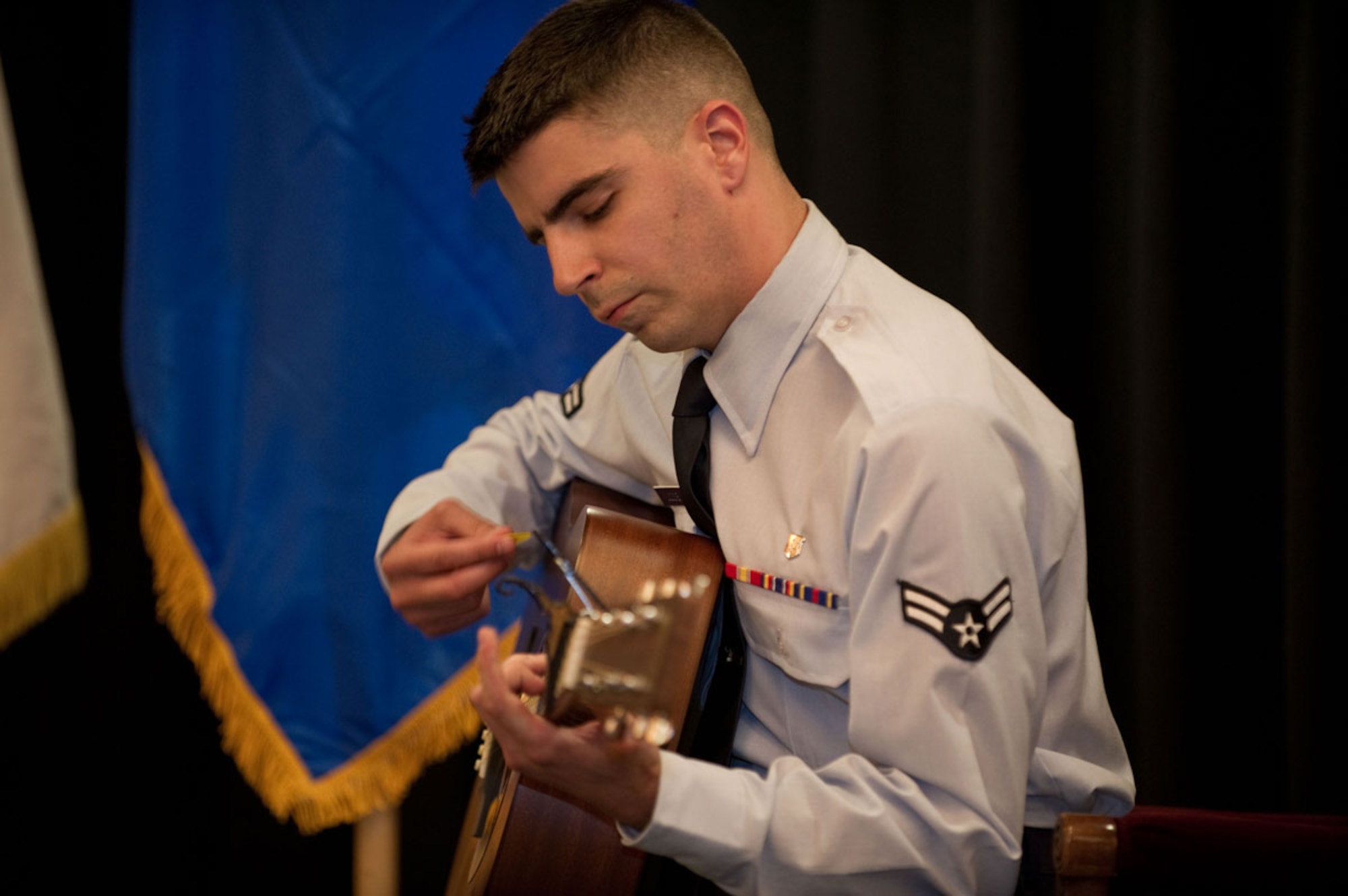 Airman 1st Class Alexander Liccione, a bioenvironmental engineer technician with the 673d Aerospace Medicine Squadron, plays an acoustic version of “I Am Woman” during the 2013 Women’s Equality Day Observance Tuesday at Joint Base Elmendorf-Richardson. (U.S. Air Force photo/Tech. Sgt. Raymond Mills)  
