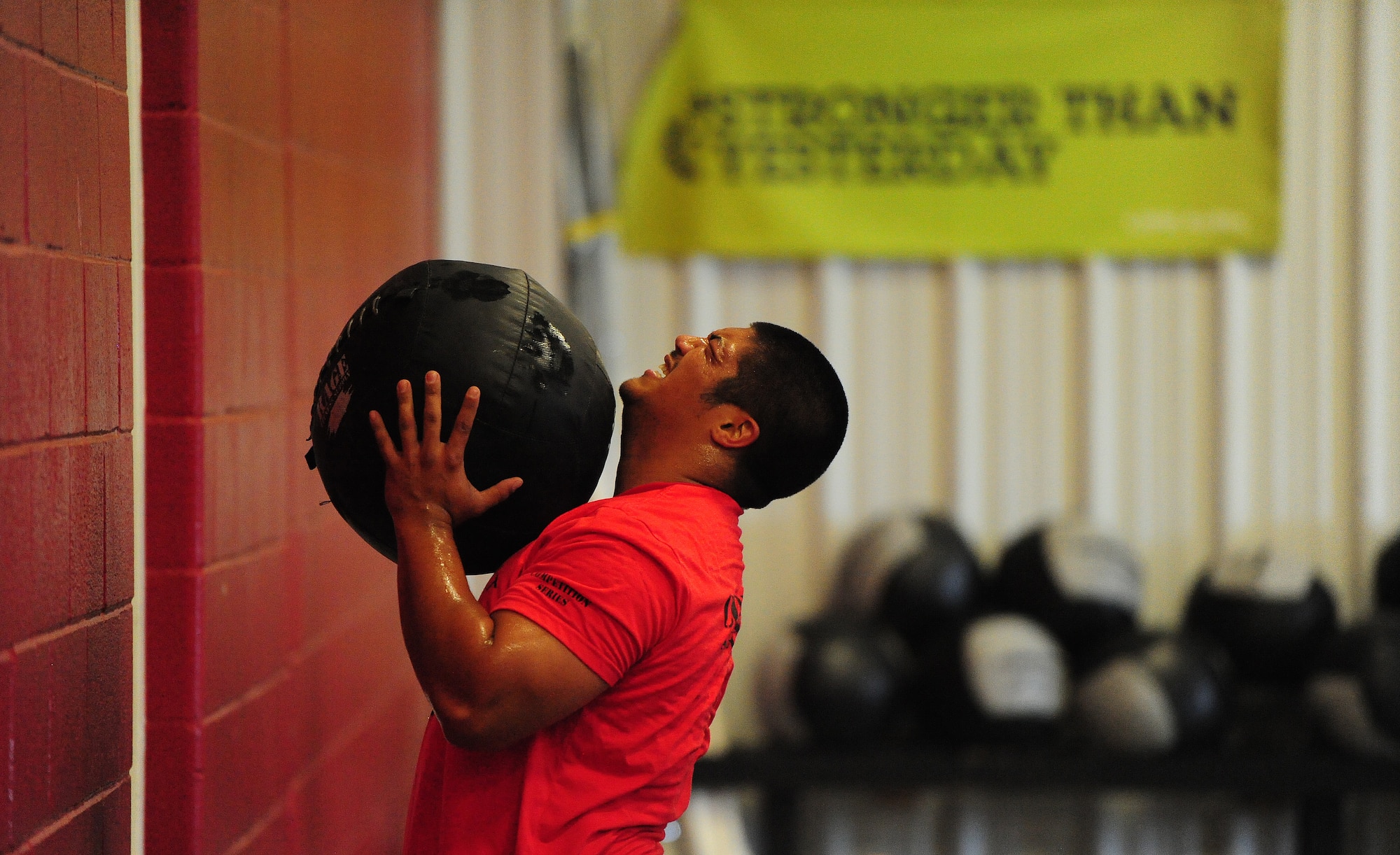 Gerald Cawelti, a U.S. Air Force Officer Training School prospect, performs 20 medicine ball squats during a competition at the CrossFit Believe gym in Warrensburg, Mo., Aug. 8, 2013.  More than 165 people at the event, including military members and civilians, raised money to support the United Brachial Plexus Network. The UBPN is a non-profit organization that works to support individuals around the world who have brachial plexus injuries. (U.S. Air Force photo by Staff Sgt. Nick Wilson/Released)