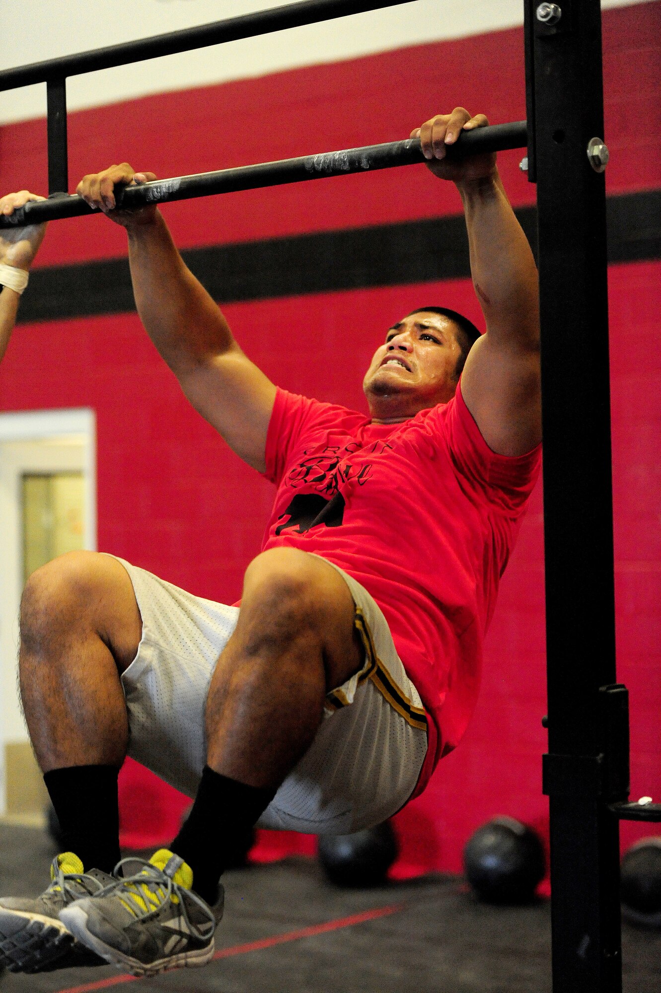 Gerald Cawelti, a U.S. Air Force Officer Training School prospect, performs a “toes to bar” exercise at a competition at the CrossFit Believe gym in Warrensburg, Mo., Aug. 8, 2013. During this exercise, Cawelti had to support his body weight while simultaneously lifting his feet to touch the bar. Cawelti performed three sets of 20 repetitions. (U.S. Air Force photo by Staff Sgt. Nick Wilson/Released) 
