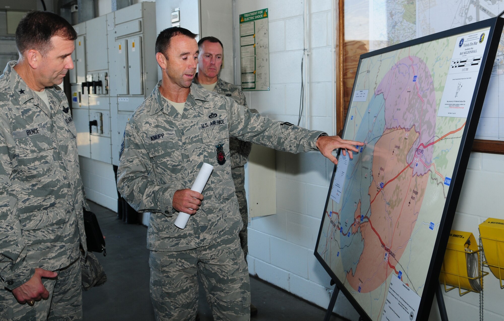 U.S. Air Force Chief Master Sgt. Scott Knupp, center, 100th Civil Engineer Squadron fire chief from Scott City, Mo., briefs U.S. Air Force Brig. Gen. Christopher Bence, left, U.S. Air Forces in Europe-UK director, on what happens when there are incidents on and off base, the location of British fire stations, and the good working relationship RAF Mildenhall has with British firefighters off base during a 100th Air Refueling Wing immersion Aug. 28, 2013, on RAF Mildenhall, England. During his immersion, the general visited the fire department, 100th Maintenance Group, 100th Logisitics Readiness Squadron and several other units. As the USAFE-UK director, Bence supports European Command, NATO, USAFE and U.S. Government agencies with thorough planning and partnering with the U.K. (U.S. Air Force photo by Karen Abeyasekere/Released)