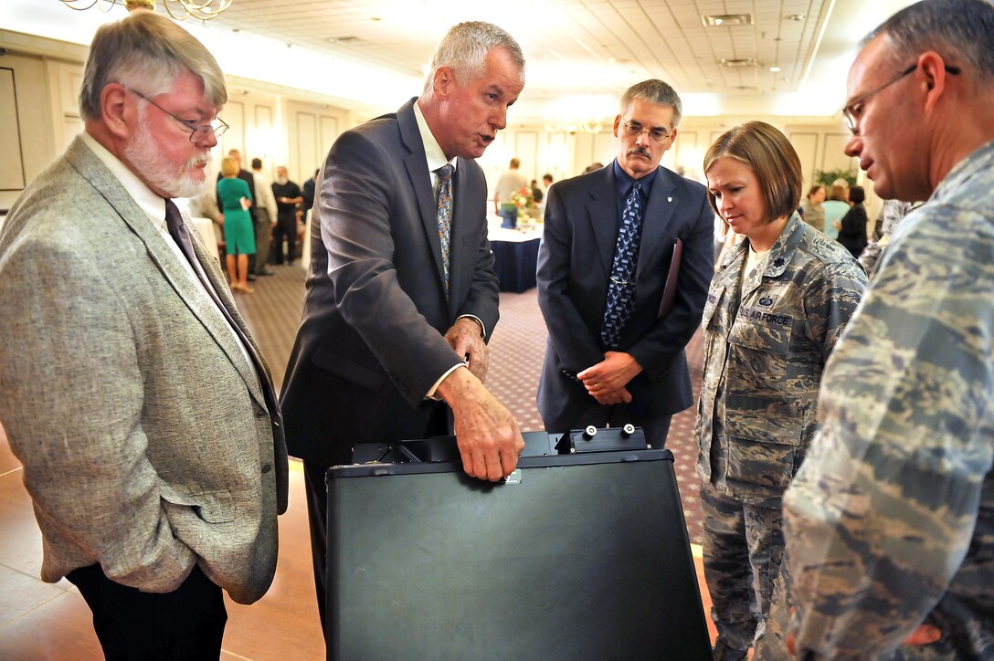 From left: Mike Callaway, signals intelligence engineer; Earl Sifford, senior business developer; John Miller, AFPEO and Director, Agile Combat Support; Lt. Col. Lea Kirkwood, Automatic Test Systems Division chief; and Col. Michael Kelly, Electronic Warfare and Avionics Division chief; discuss the JSECST electronic warfare tester.  (U.S. Air Force photo by Tommie Horton)
