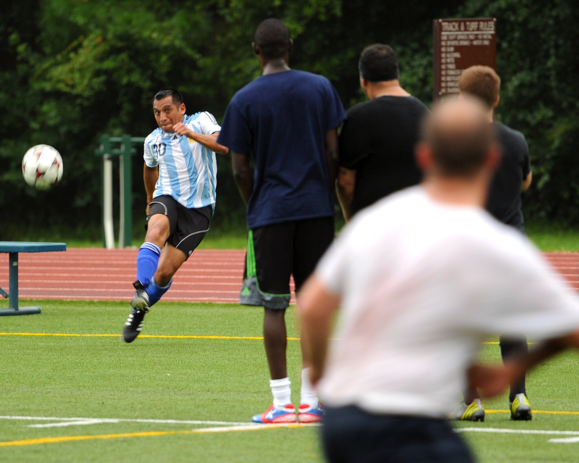 A 9th Special Operations Squadron soccer player attempts to corner kick around a row of 1st Special Operation Force Support Squadron members during the final game of the 2013 Hurlburt Field Intramural Soccer Playoffs at the Alderholt gym on Hurlburt Field, Fla., Aug. 16. The 9th SOS defeated the 1st SOFSS in double overtime, 2-1, winning the tournament.. (U.S. Air Force photo/Senior Airman Kentavist P. Brackin) 