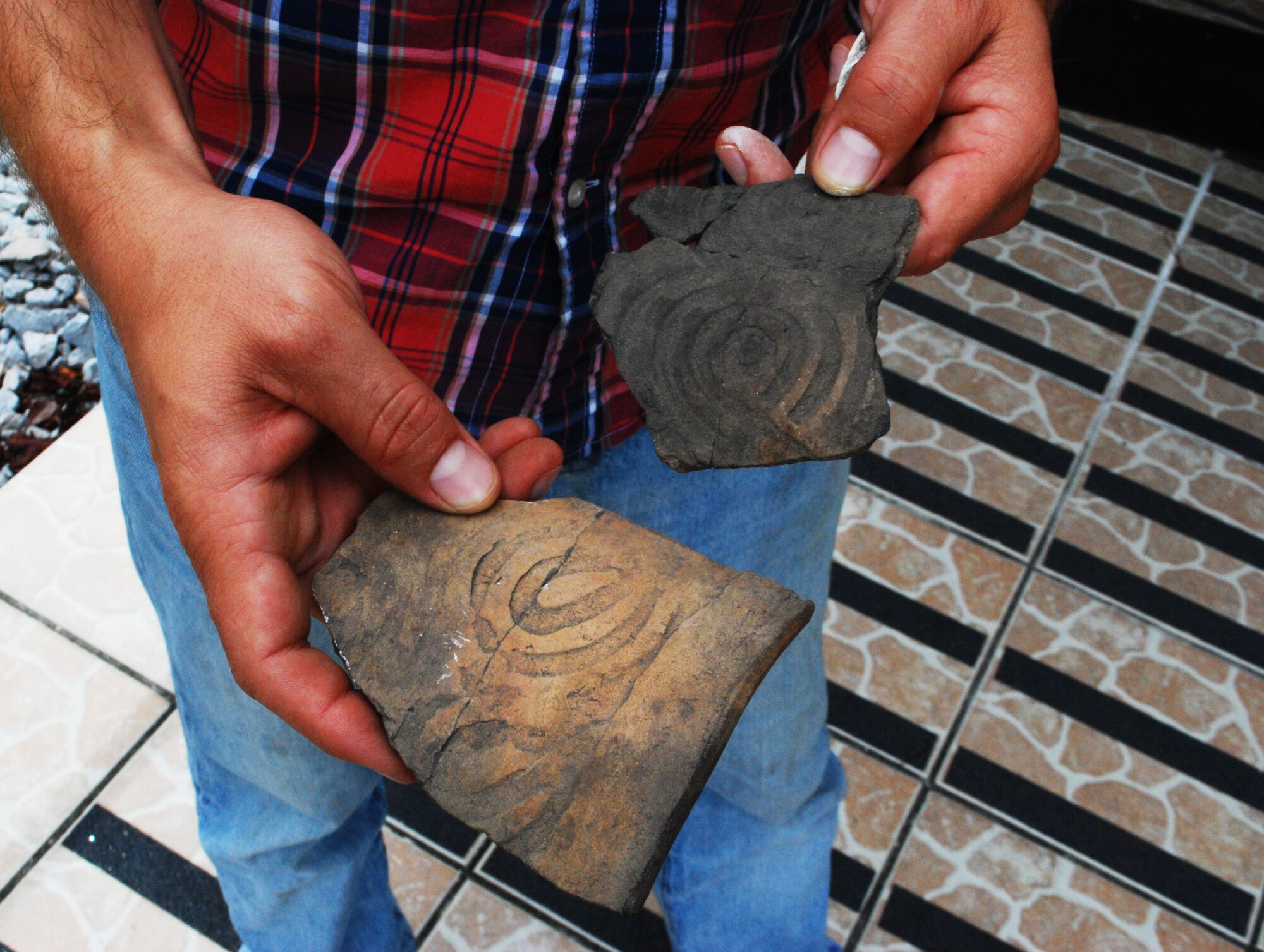 Mr. Dengel holds two artifacts that have been found at Tyndall while at the 325th Civil Engineer Squadron Natural Resources building Aug. 26. The intricate design on these artifacts can reveal the amount of time it took to make them, and who they may have been made for. (U.S. Air Force image by 2nd Lt. Christopher Bowyer-Meeder) ) 