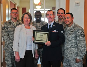 Senior Airman James Barrett, 11th Contracting Squadron contract specialist, stands with members of his unit and  Mary Jette, Liberty Park at Andrews community manager, after being awarded a $2,000 scholarship, Aug. 28, 2013, at Joint Base Andrews, Md.The Michaels Organizational Educational Foundation scholarship at Liberty Park seeks to enhance residents of its housing community’s educational opportunities. (U.S. Air Force photo/ Ms. Amber J. Russell)