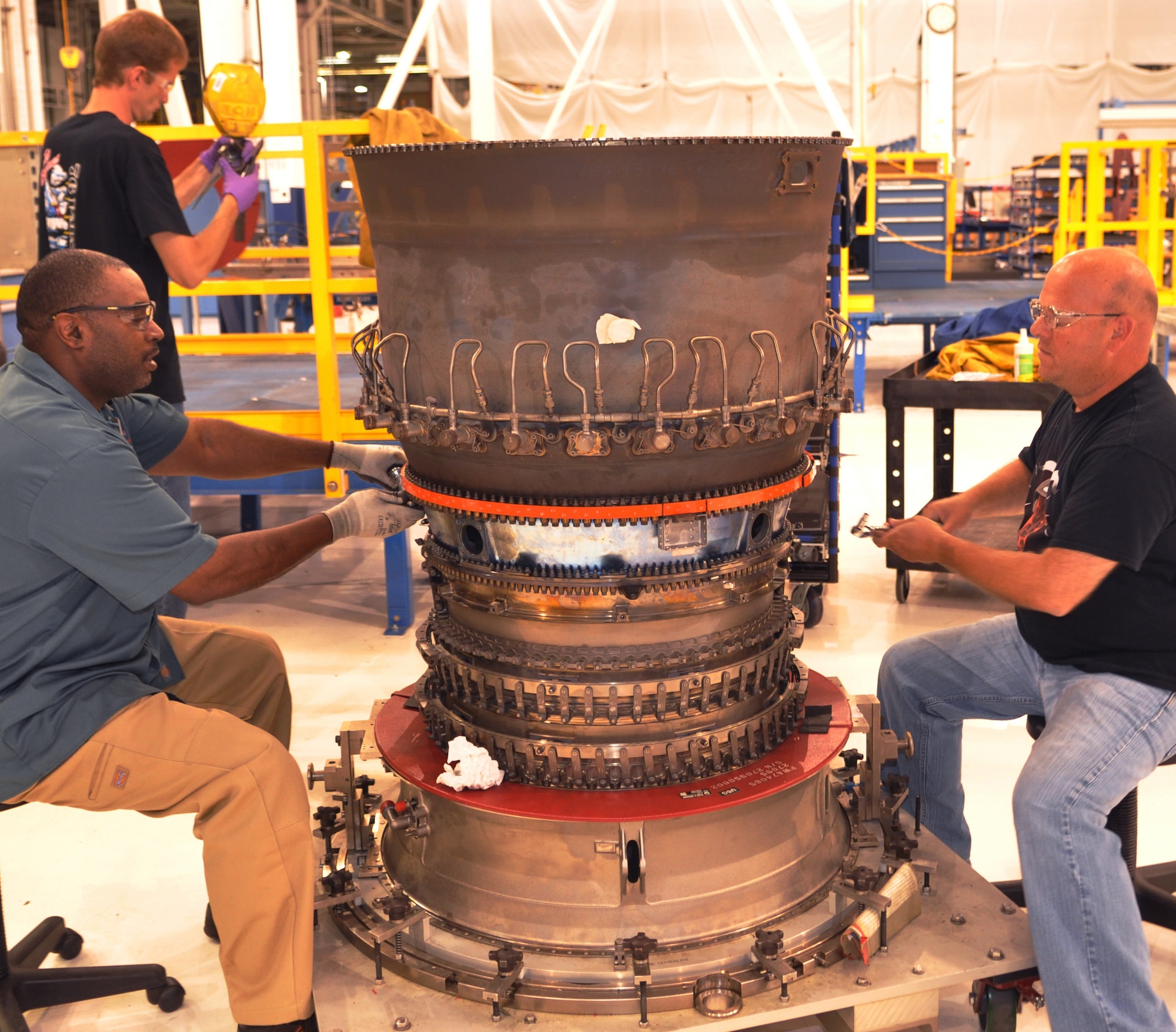 Aircraft mechanics Ira McFadden, left, of the 548th Propulsion Maintenance Squadron, and Mike Blackmore of the 76th Propulsion Maintenance Group torque the diffuser on an F119 jet engine. The diffuser is where the jet fuel is atomized, or reduced to a fine spray.(U.S. Air Force photo by Mike Ray)