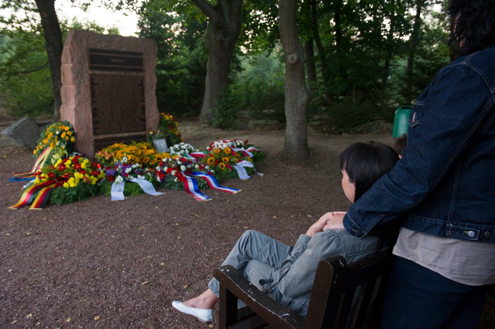 RAMSTEIN, Germany -- Mourners pay their respects at the memorial site of the 1988 Ramstein air show disaster, Aug. 28, 2013. People gathered on the 25th anniversary of the disaster to remember the 70 people who died when and Italian aerial demonstration team crashed during the show. (U.S. Air Force photo/Tech. Sgt. Benjamin Wilson)