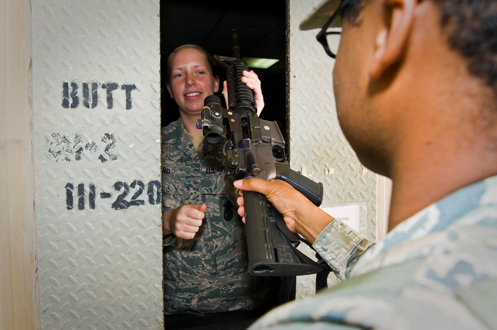Airman 1st Class Jillian Ward issues an M4 carbine assault rifle to Senior Airman Thomas Flowers at the 379th Air Expeditionary Wing in Southwest Asia, Aug. 14, 2013. Ward is a 379th Expeditionary Security Forces Squadron staff armorer deployed from Mountain Home Air Force Base, Idaho, and hails from Sunbury, Ohio. Flowers is a 379th ESFS security forces leader deployed from Royal Air Force Lakenheath, England, and a Washington, D.C., native. (U.S. Air Force photo/Senior Airman Benjamin Stratton)