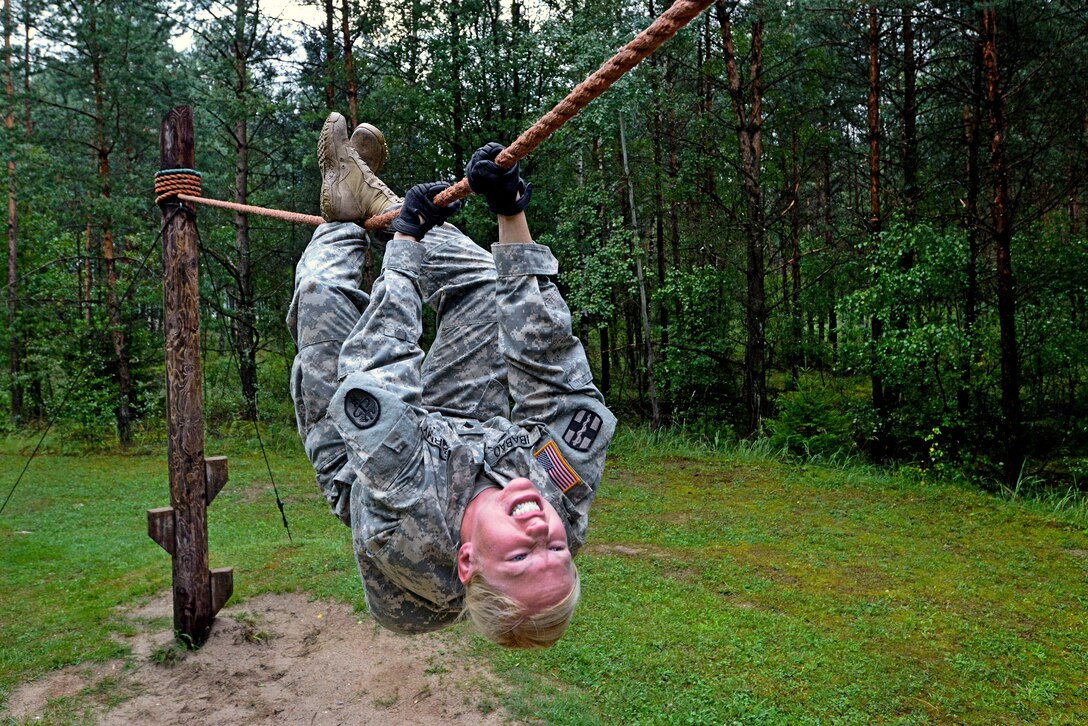 U.S. Army Spc. Elizabeth Ibabao crosses a rope bridge on the obstacle ...